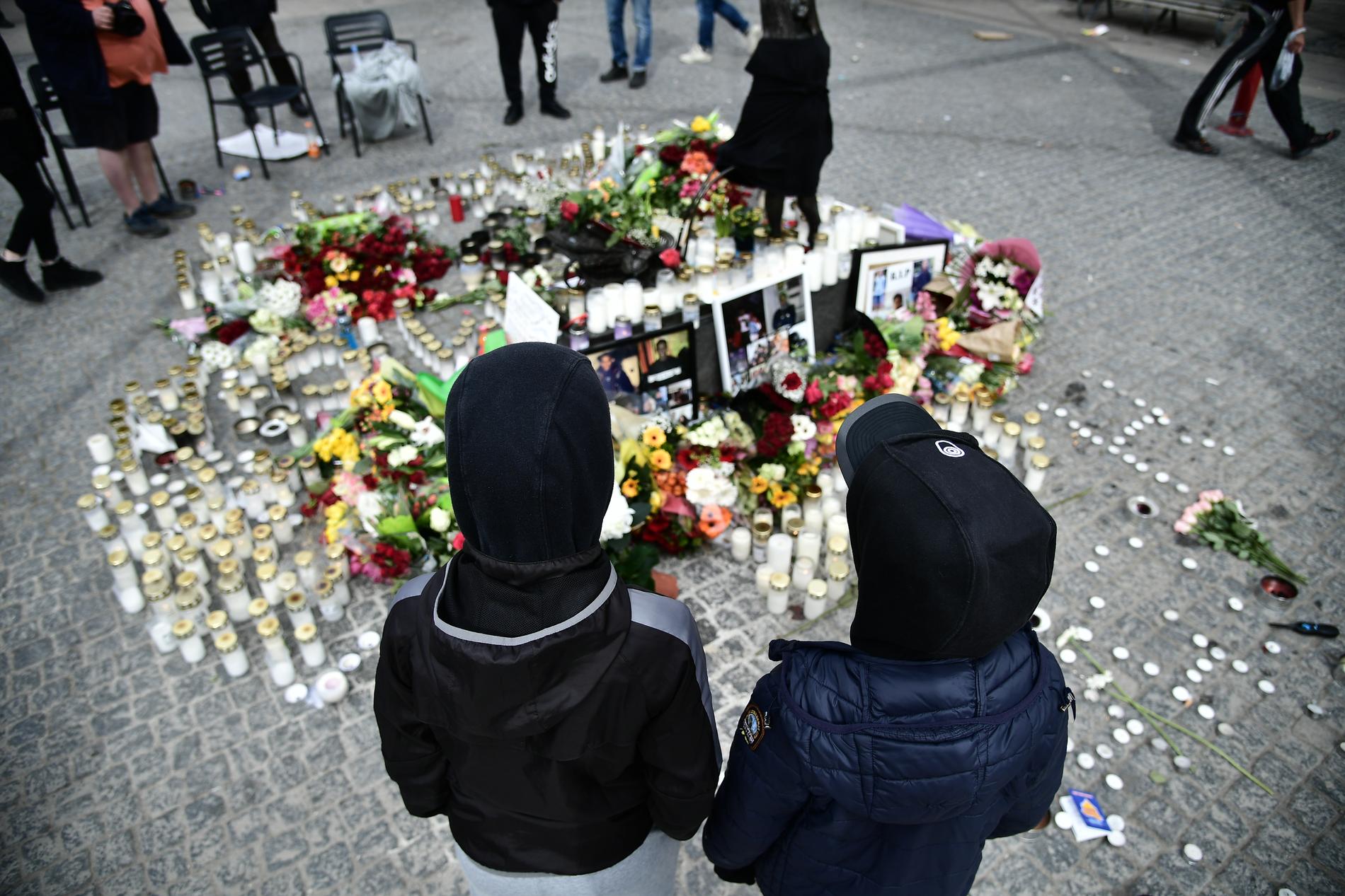 De unga männen som mördats hedras med blommor och ljus på torget i Sätra centrum.