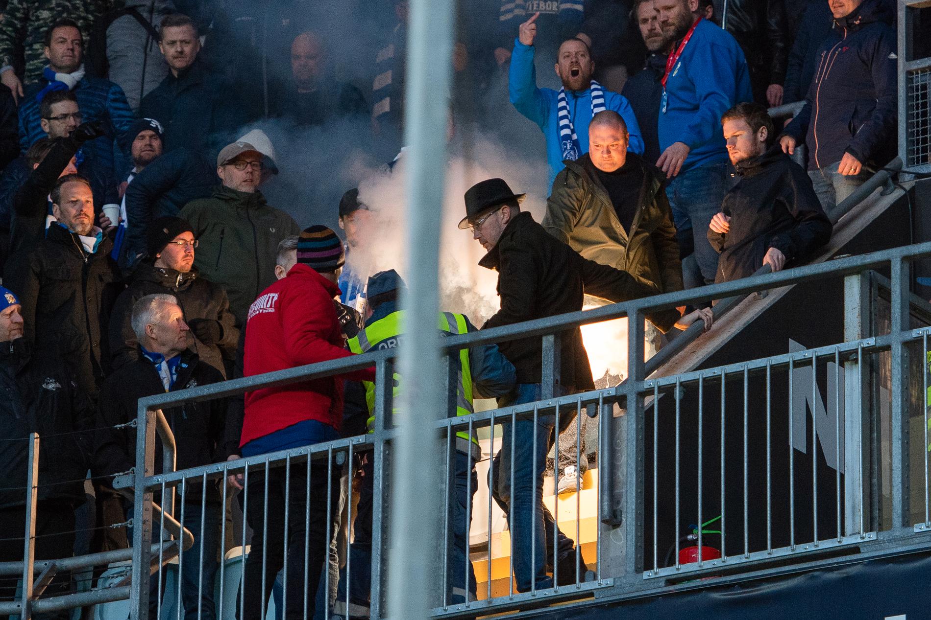 En bengal tas om hand efter att en Hammarbysupporter (ej i bild) kastat in den mot IFK Göteborgs supportrar under matchen.