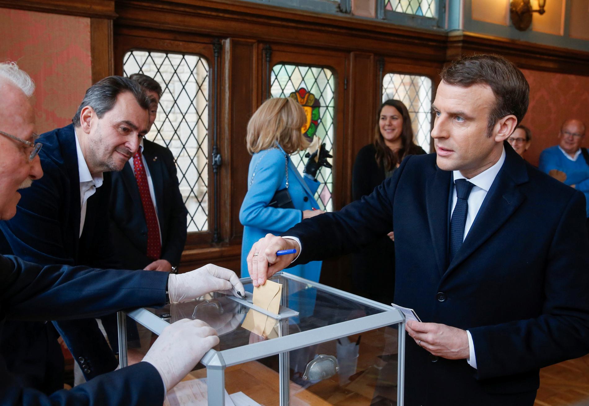 Valförrättaren bar handskar när president Emmanuel Macron lade sin röst i borgmästarvalet i Le Touquet i norra Frankrike på söndagen.