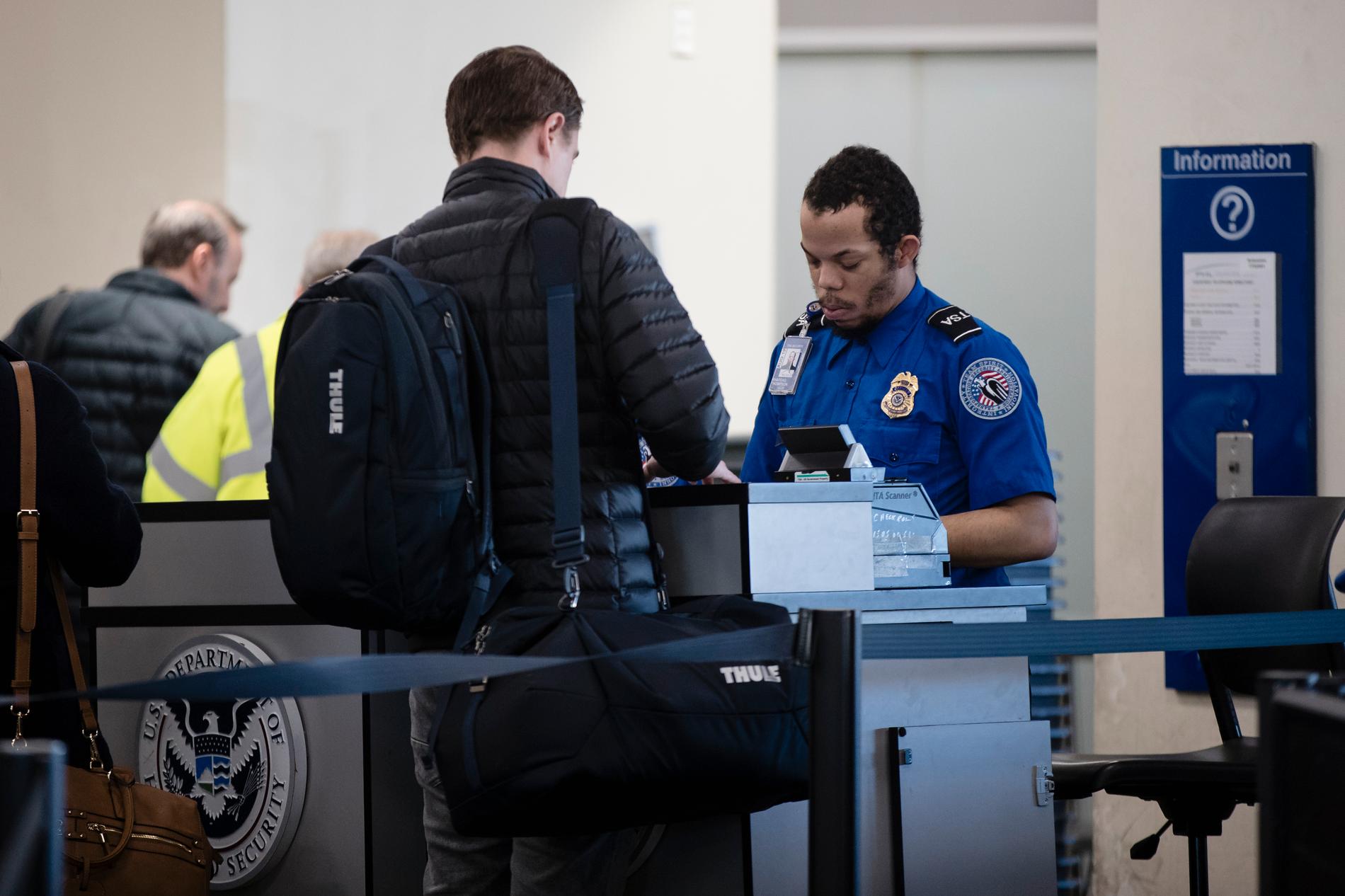 Säkerhetspersonal undersöker passagerare på den internationella flygplatsen i Philadelphia. Arkivbild.