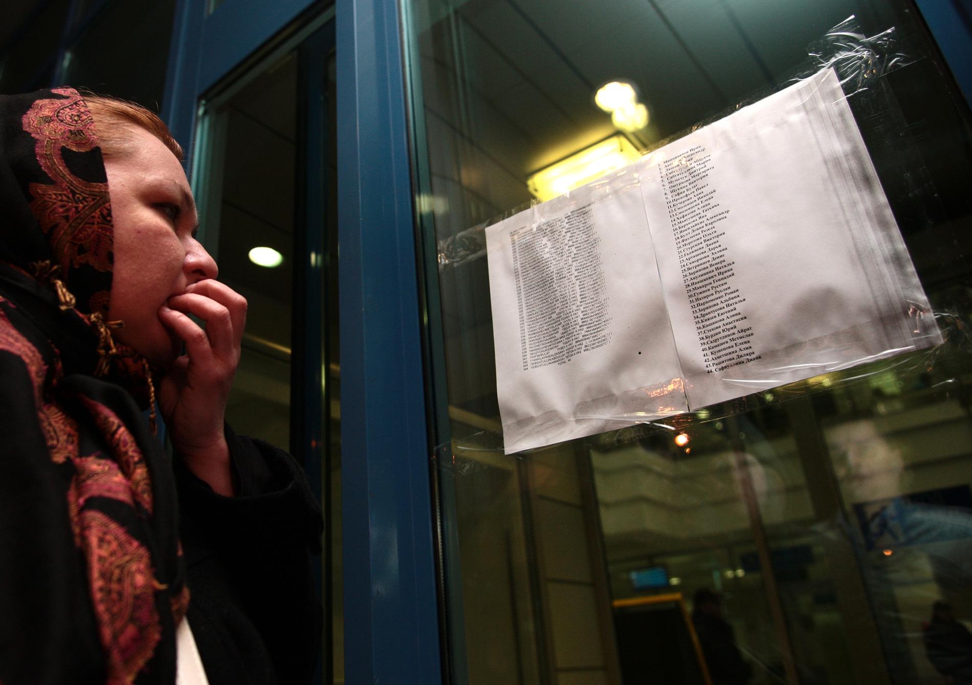 En kvinna läser namnen på passagerarlistan för flygplanet som kraschade i Kazan i Ryssland i november 2013. Arkivbild.