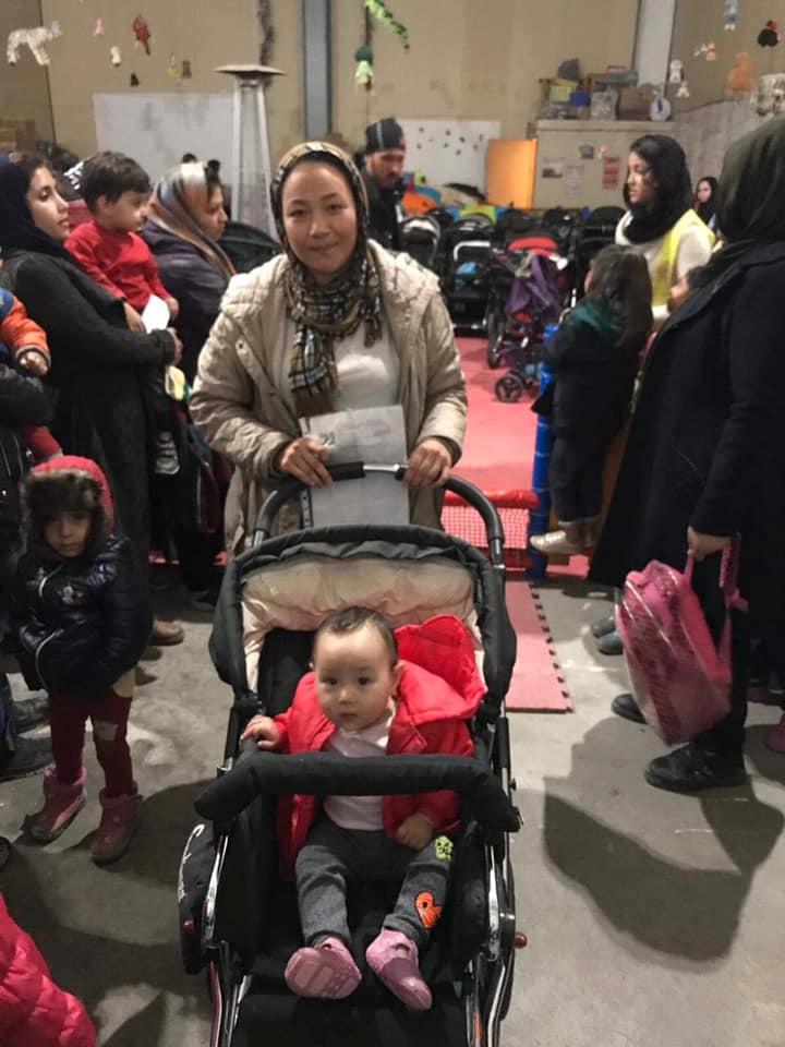 Tacksamma mammor tar emot barnvagnarna i flyktinglägret.