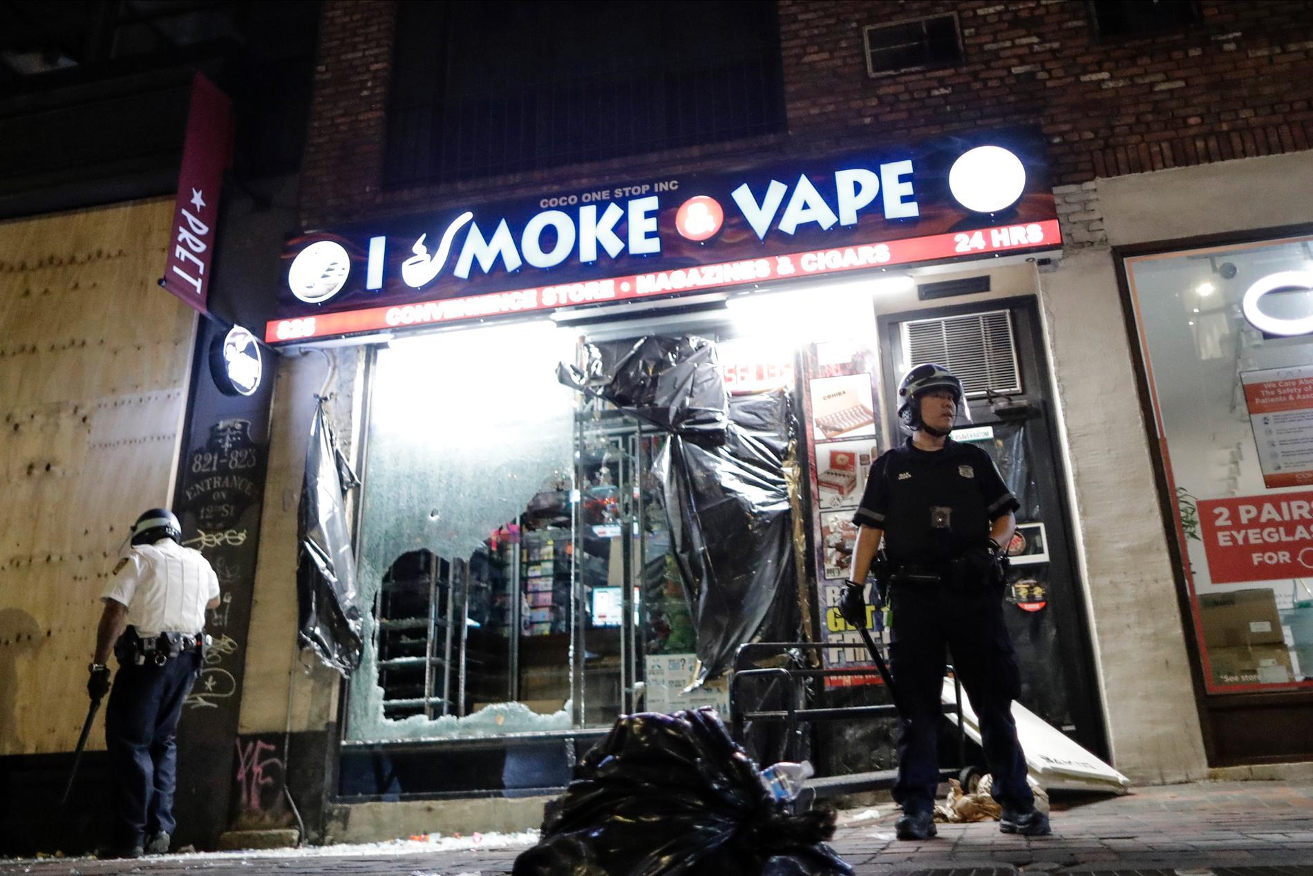 Polis bevakar en plundrad butik i New York.