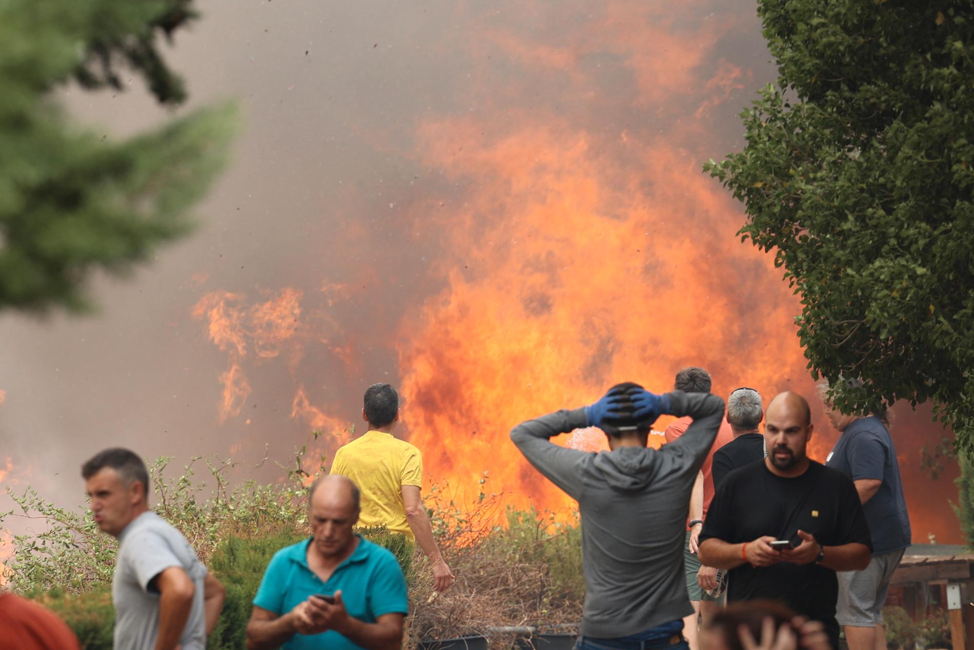 Grannar står nära en skogsbrand i Anon de Moncayo, Spanien, augusti 2022.
