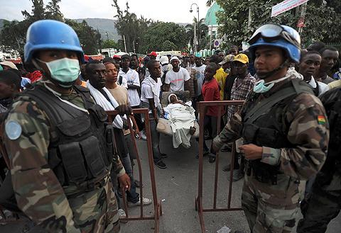 En skadad anländer till ett av FN:s hjälpcenter i Port-au-Prince. Vid världsorganisationens matlager har människor börjat plundra för att stilla sin hunger.