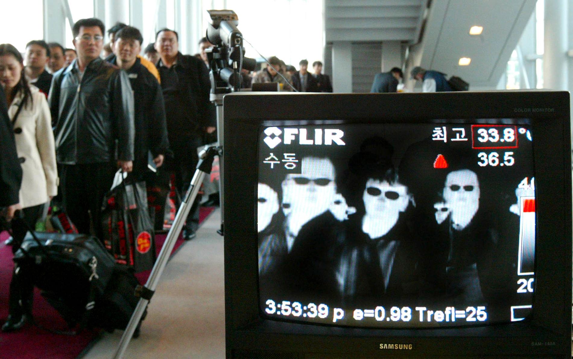 En kamera som mäter kroppstemperaturen övervakar resenärer på en flygplats i Sydkorea 2003, för att upptäcka passagerare med feber och förhindra spridning av sars. Nu väcker ett nytt, okänt lungvirus minnen av sars-epidemin. Arkivbild