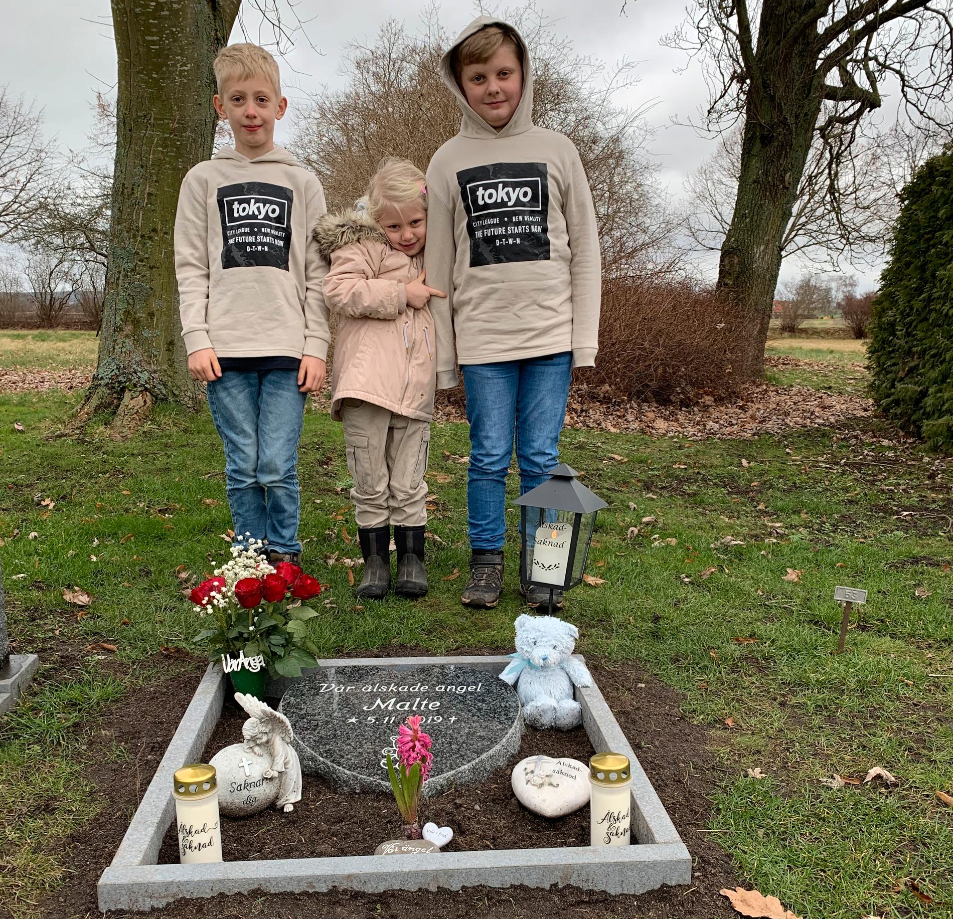 Hampus 9 år, Agnes 5 år och Dennis 10 år vid deras lillebrors grav.