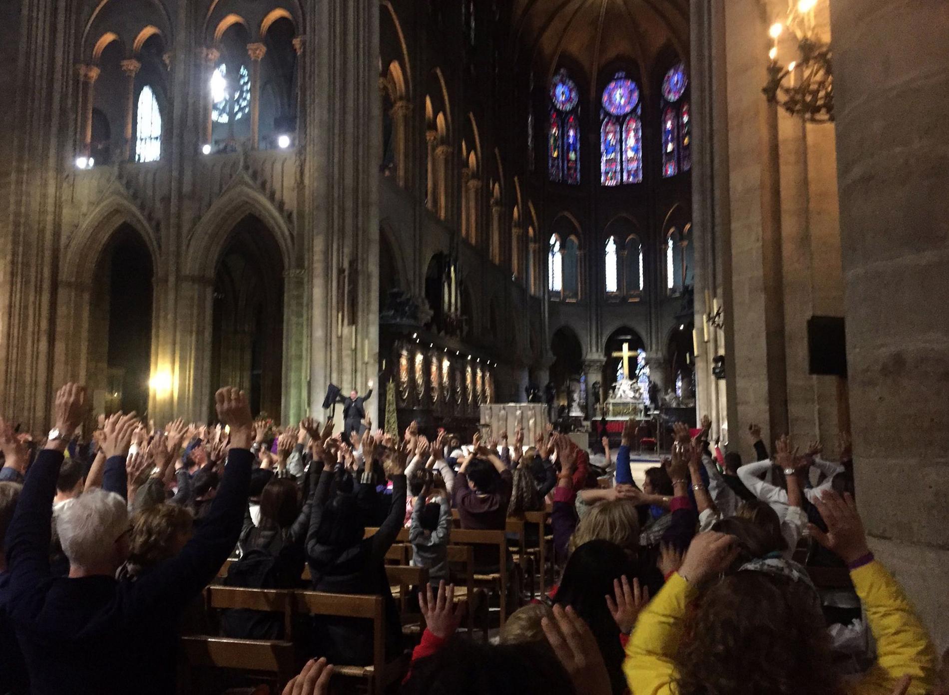 Människor inne i katedralen höjer armarna under pågående drama på polisens uppmaning.