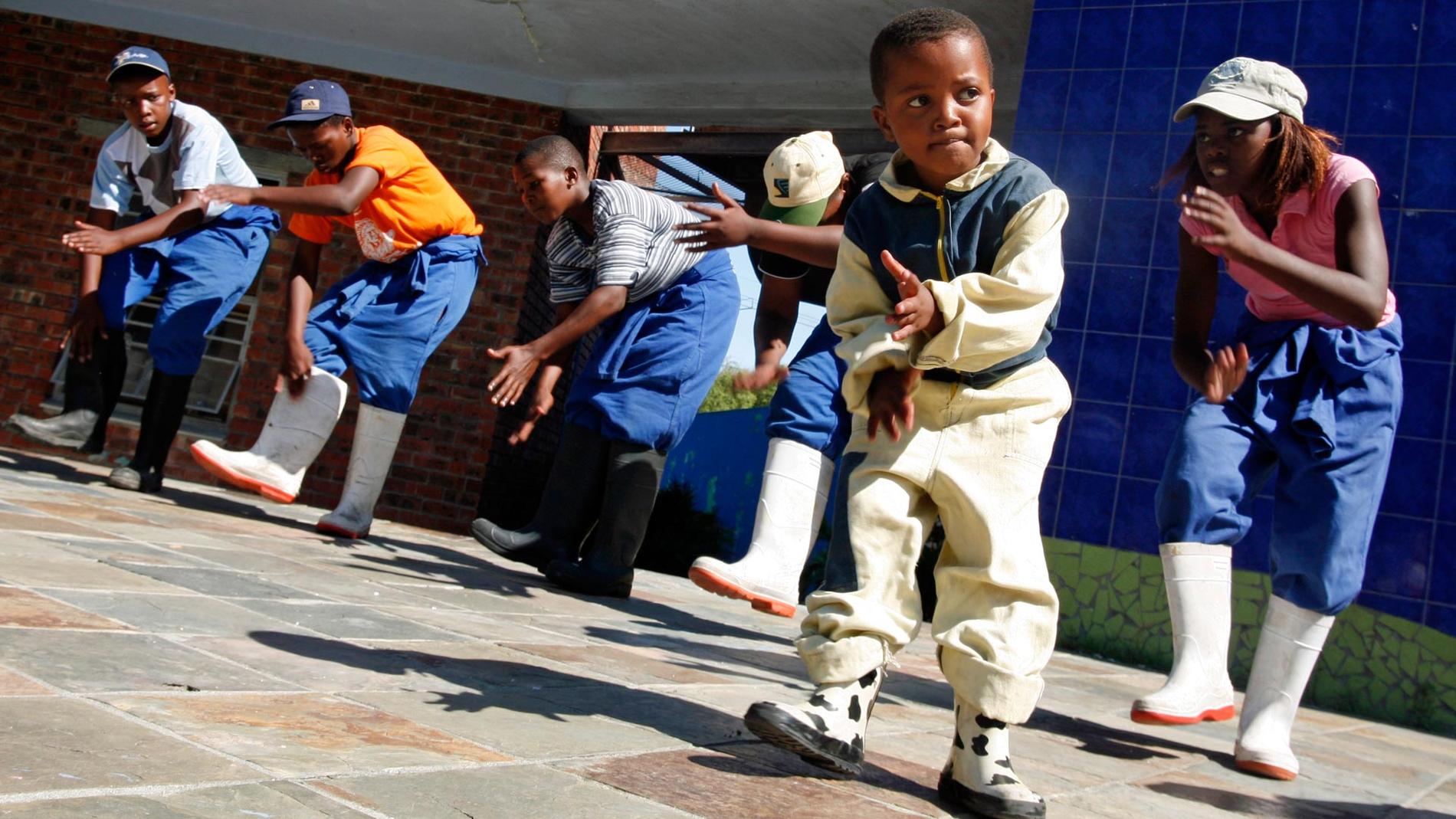 En grupp barn visar en gumboots dance, som skapades av svarta gruvarbetare under apartheidåren. Guga S’Thebe Arts And Culture Centre, i townshipet Langa.
