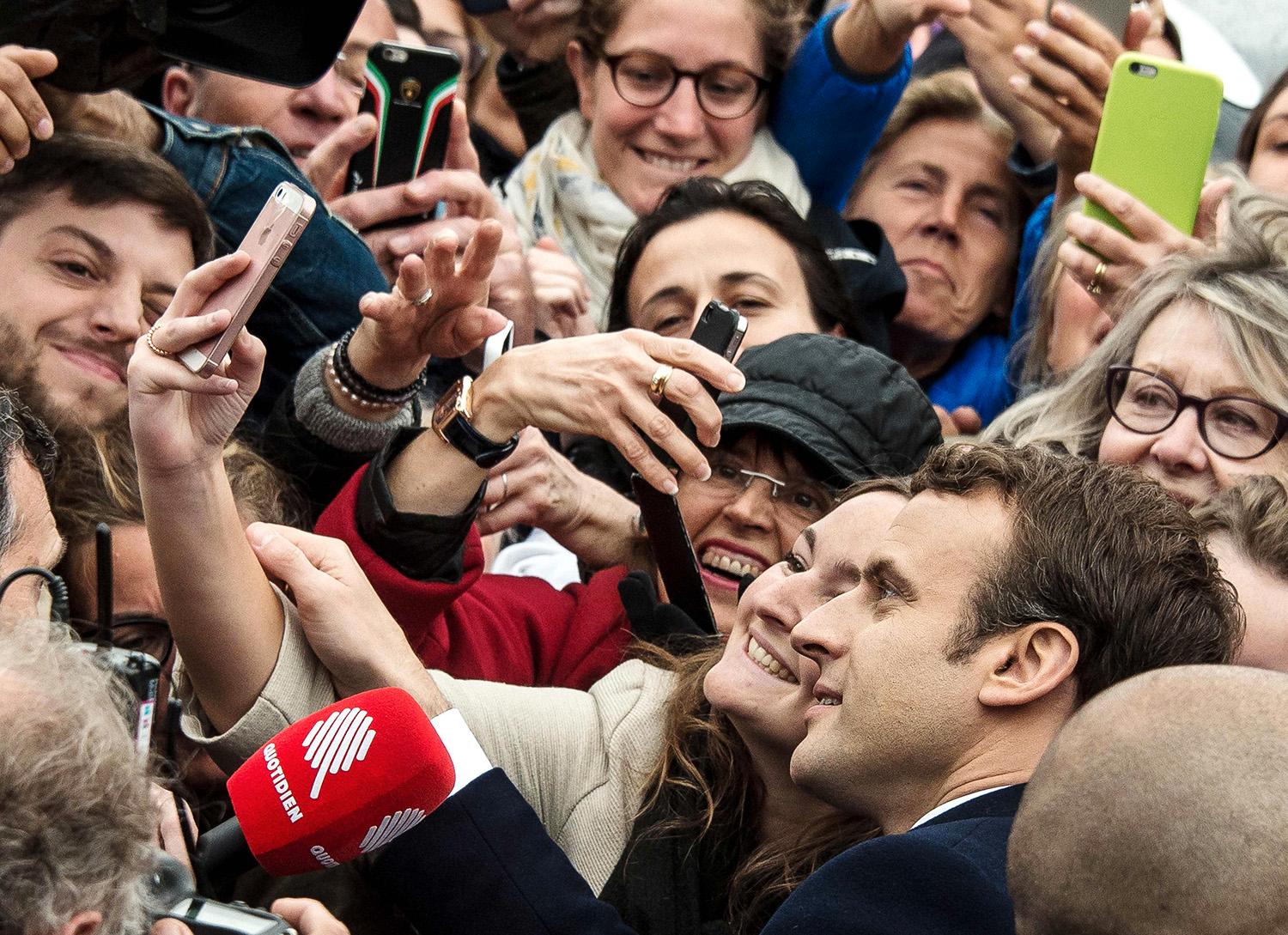 Macron tar en selfie med en supporter. 
