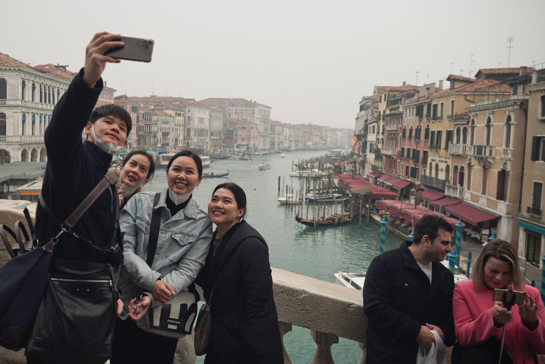 Turister i skyddsmasker i Venedig, Italien, där antalet smittade har ökat dramatiskt. 
