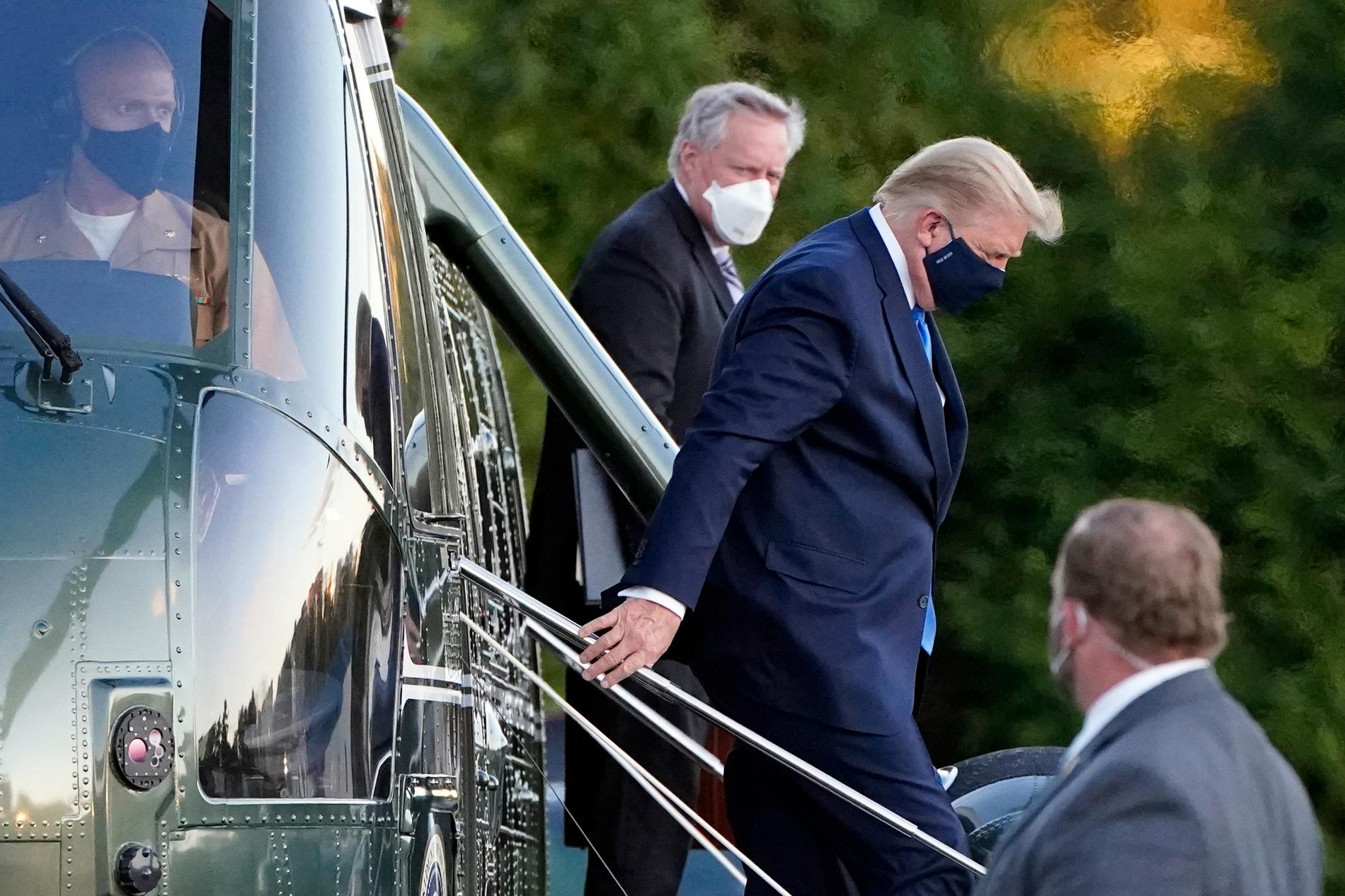 Donald Trump och stabschefen Mark Meadows lämnar helikoptern Marine One utanför sjukhuset.