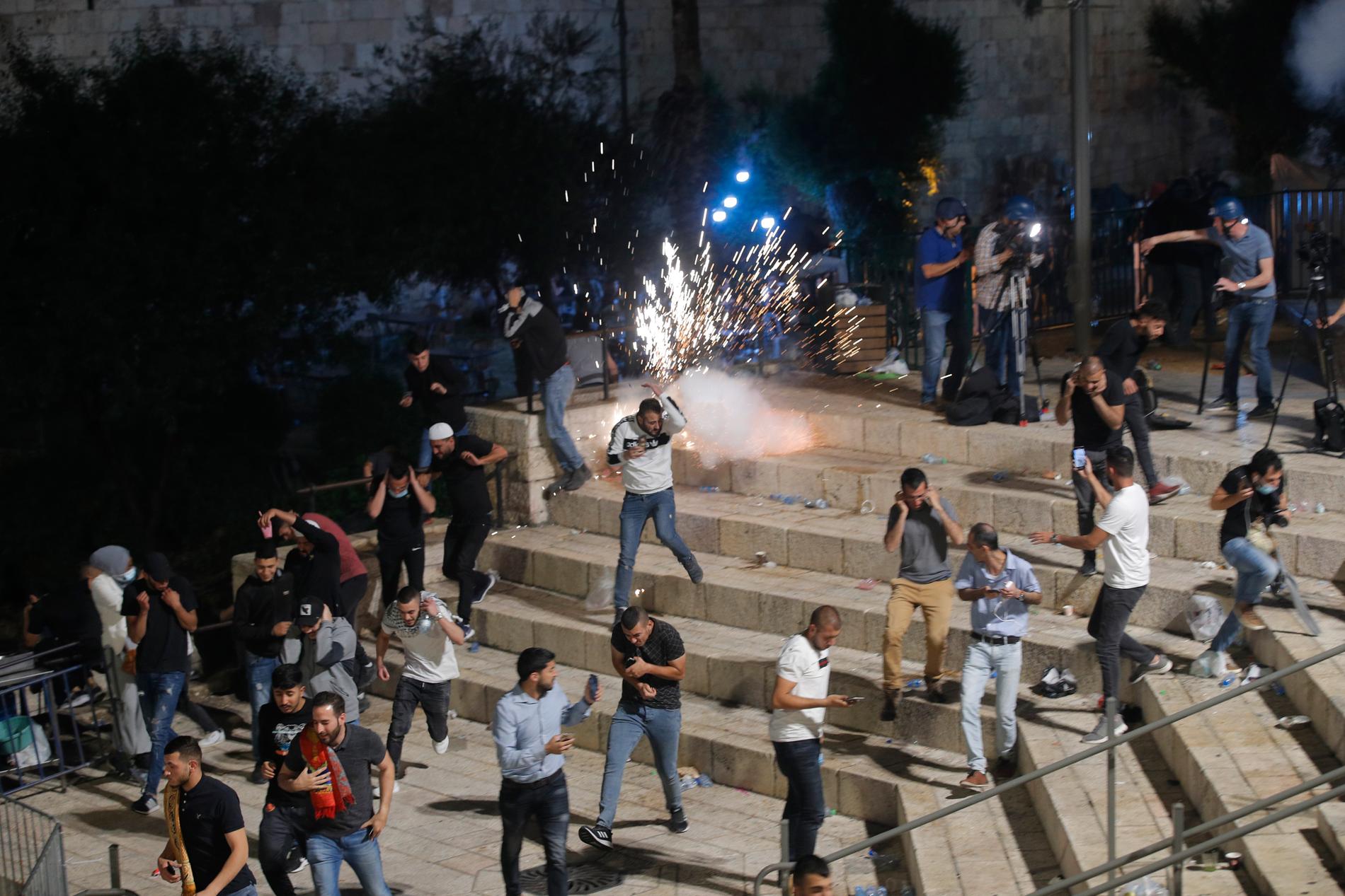 Palestinier flyr från polisens distraktionsgranater vid Damaskusporten precis utanför Jerusalems gamla stad på lördagskvällen.