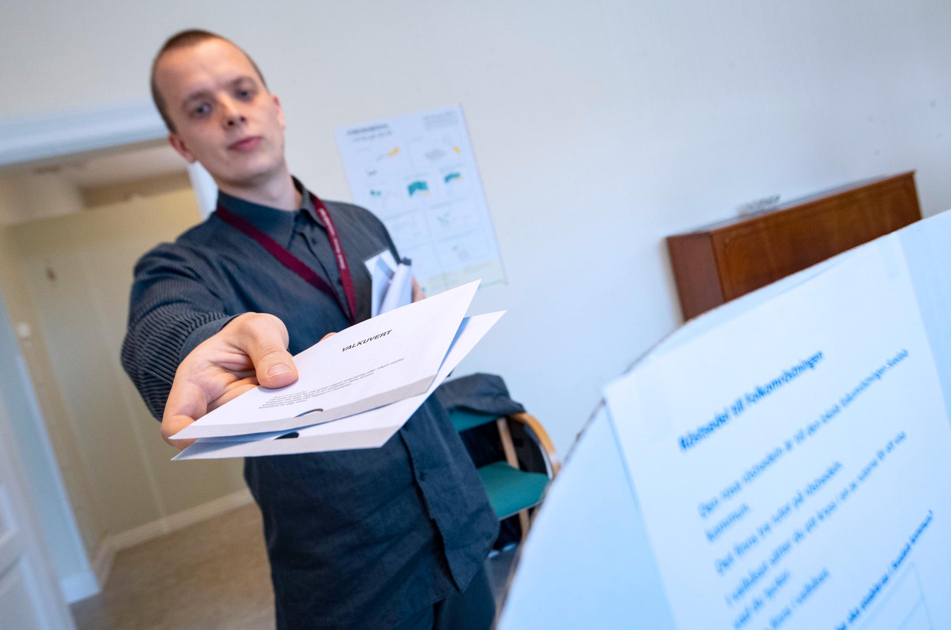 Anton Almer lämnar ut de två valkuverten i lokalen för förtidsröstning vid Stortorget i centrala i Svedala.