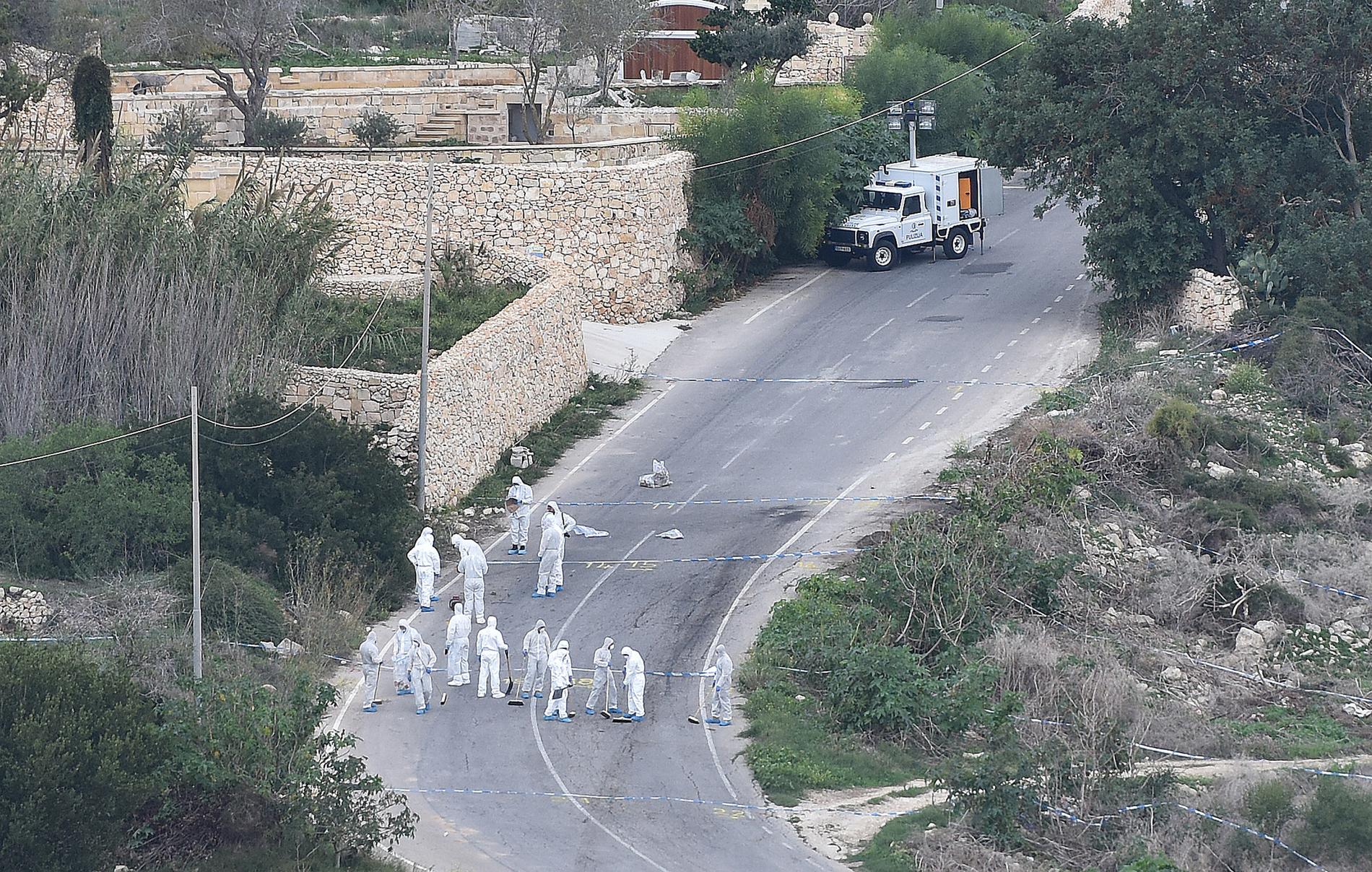 Polisens rättstekniker arbetar, tre dagar efter mordet, vid platsen där bomben i Daphne Caruana Galizias bil detonerade.