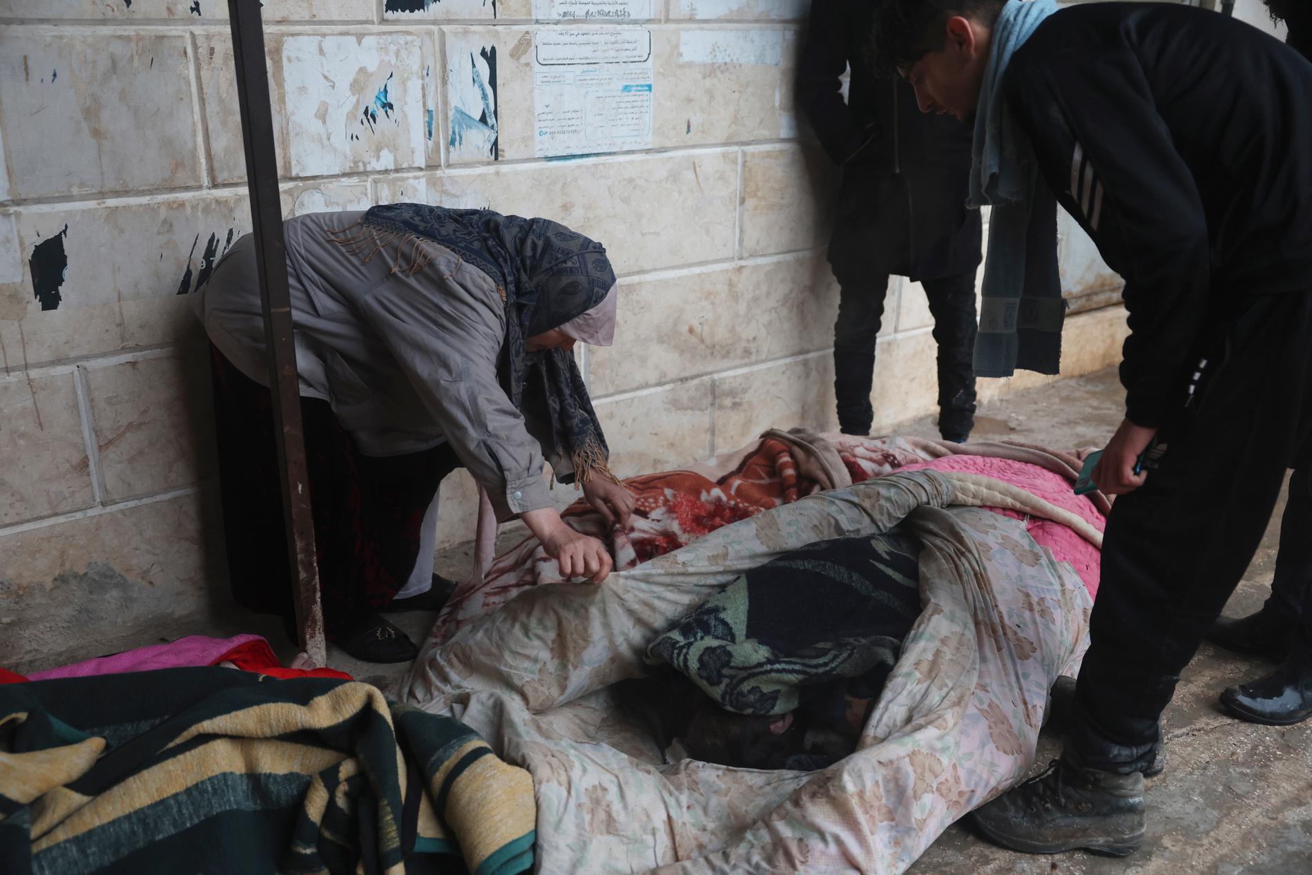 En kvinna försöker identifiera kropparna av jordbävningsoffren som hittats i Azmarin, en by i norra Syrien. 