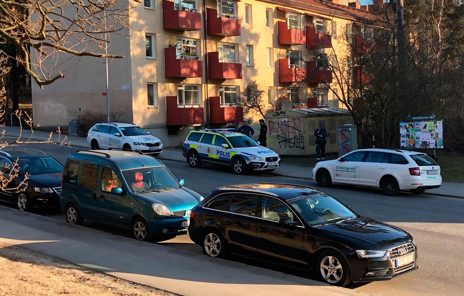 Poliser i samspråk med väktare, en bit från Årsta torg.