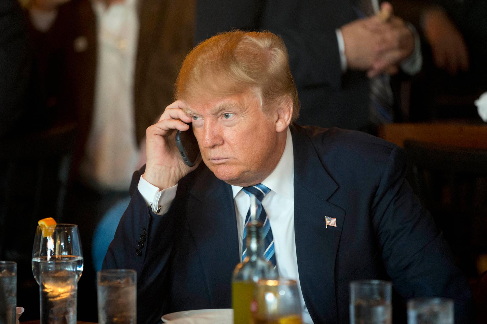 Vilken telefon använder Donald Trump här? En av de två krypterade eller den som är helt oskyddad? Arkivbild.