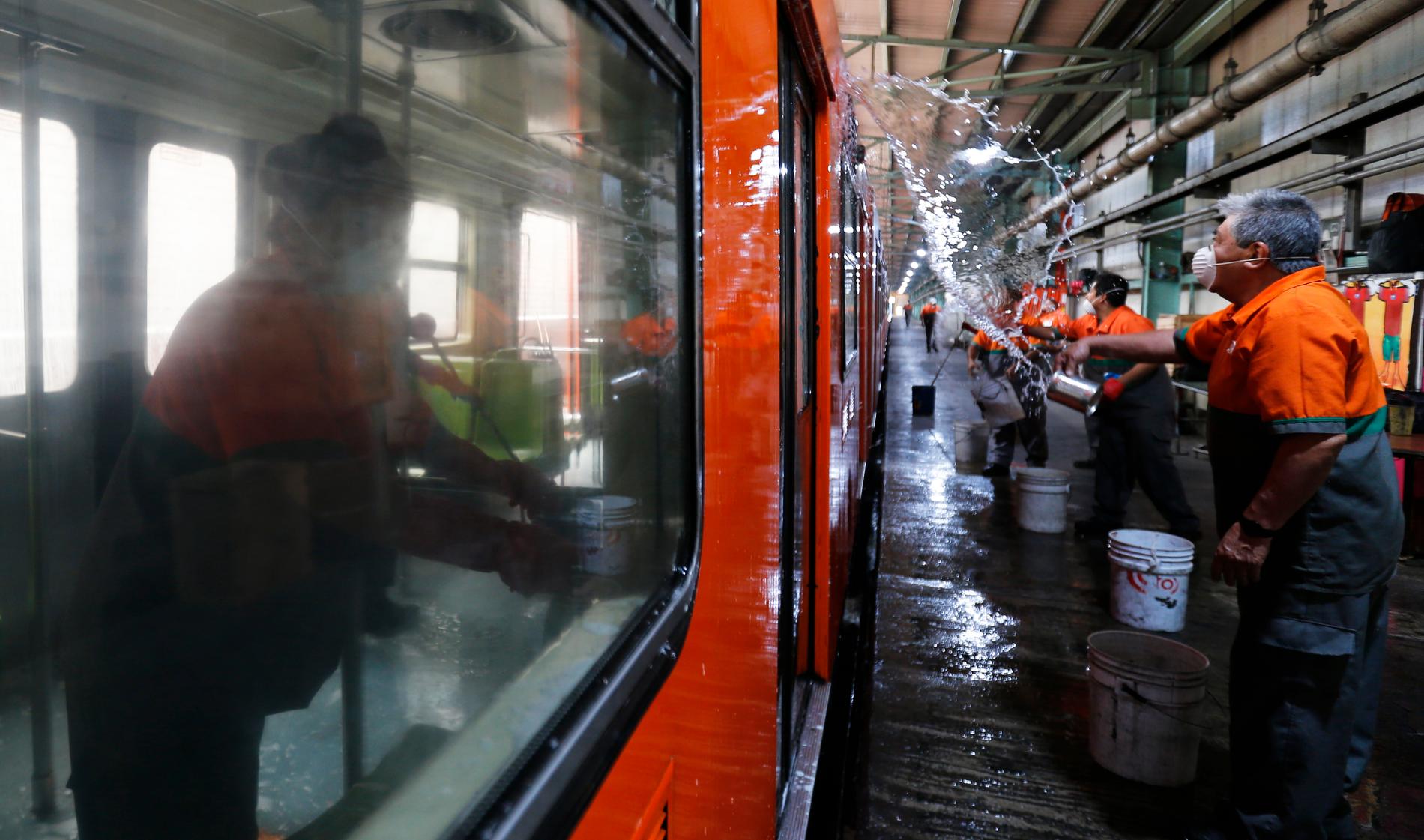 Renhållningsarbetare tvättar en tunnelbanevagn i Mexico City i syfte att motverka spridningen av det nya coronaviruset.