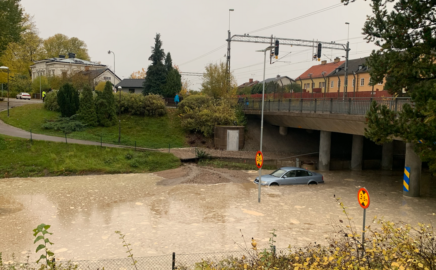 Bilder visar hur en bil står nästan helt under vatten på platsen.