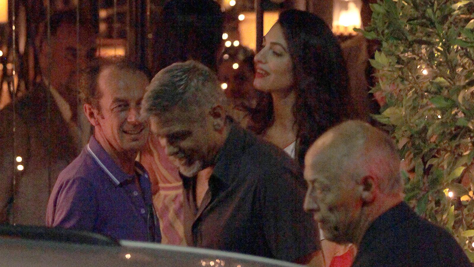 George och Amal Clooney fångades på bild med vänner när de besökte restaurangen Il Gatto Nero vid Comosjön i Italien.