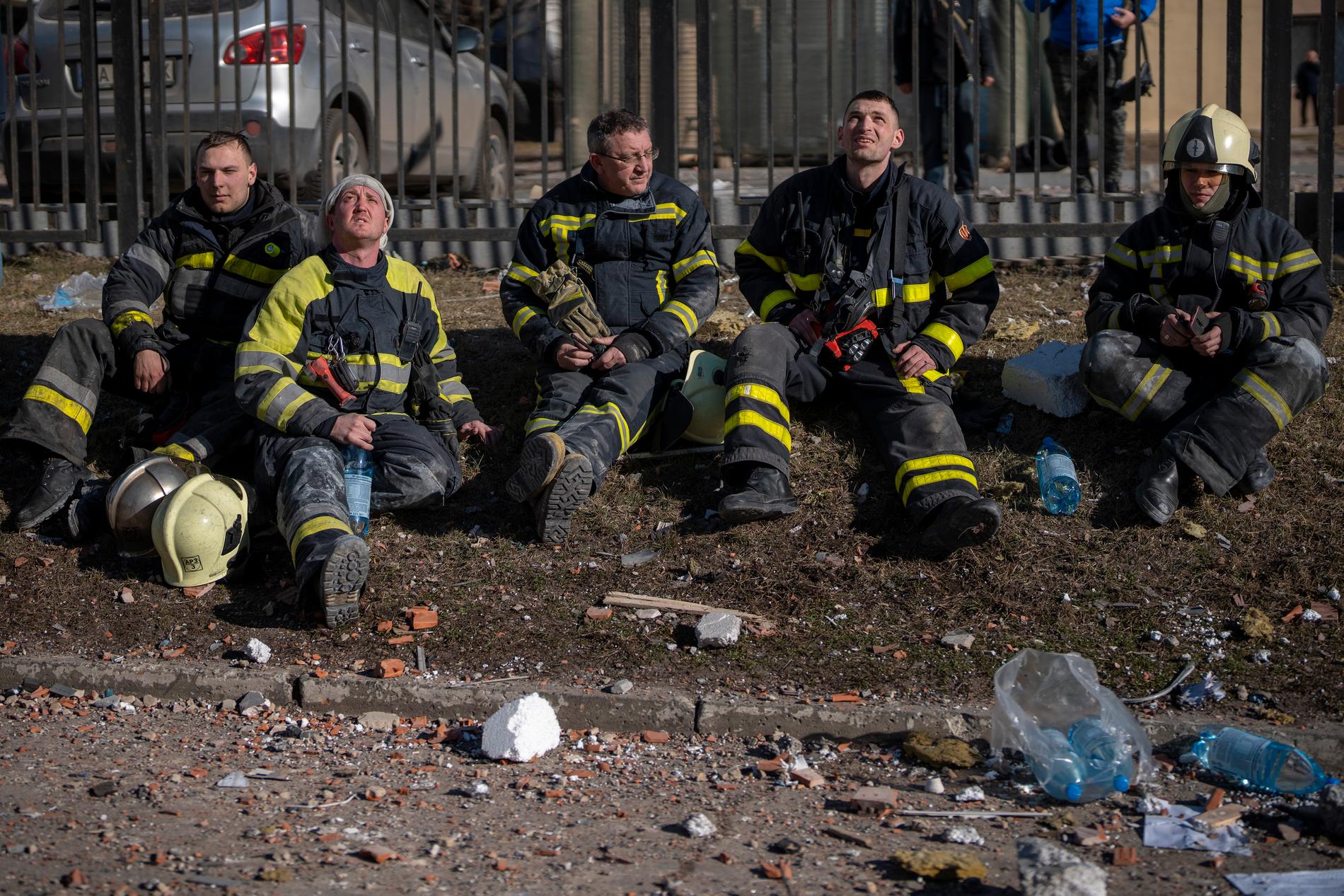 Ukrainska brandmän vilar efter att ha släckt en brand utlöst av en robotattack mot ett flerfamiljshus. 