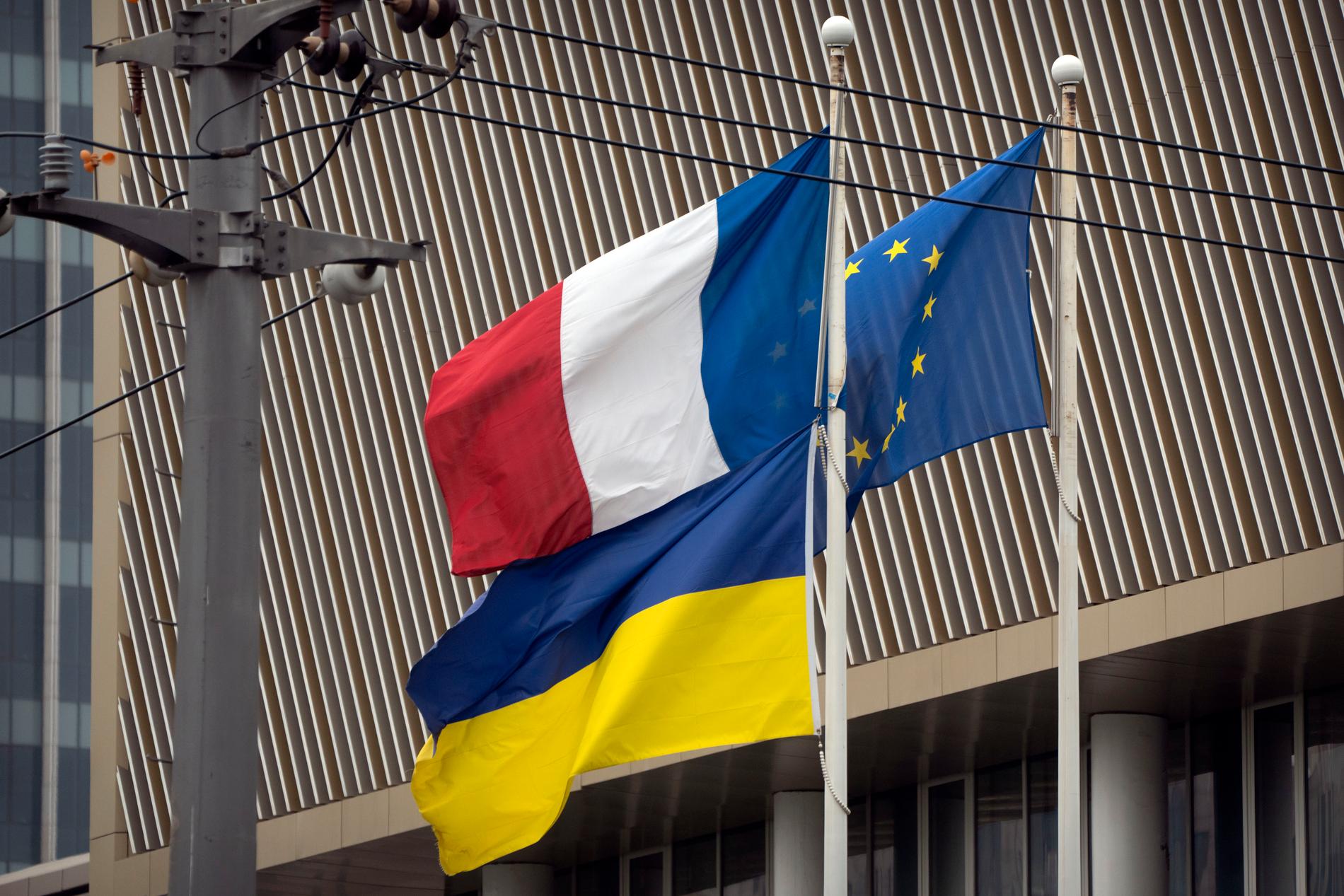 Franska trikoloren vajar i vinden tillsammans med den ukrainska och EU:s flagga.