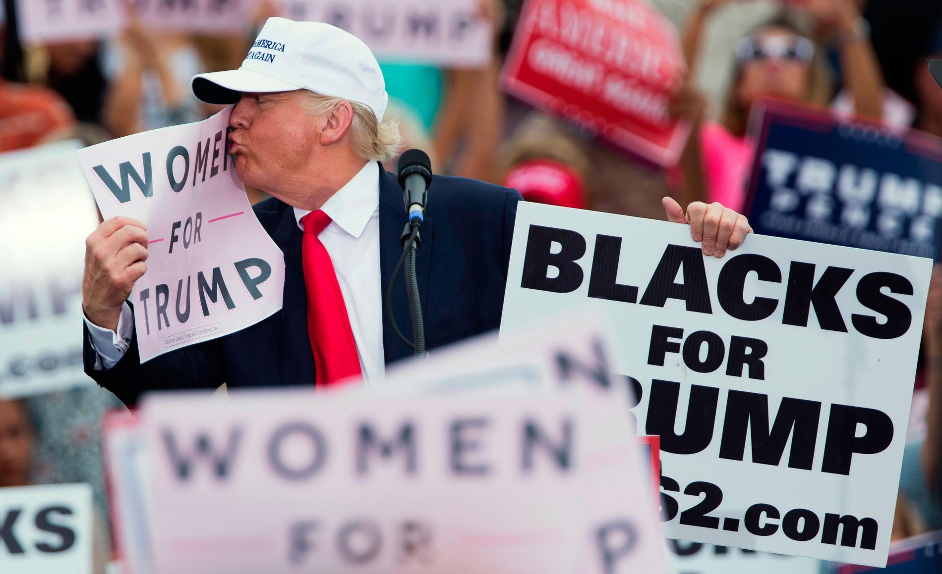 Republikanernas presidentkandidat Donald Trump kysser en ”Women for Trump”-skylt under ett väljarmöte i Lakeland, Florida, under onsdagen den 12 oktober.