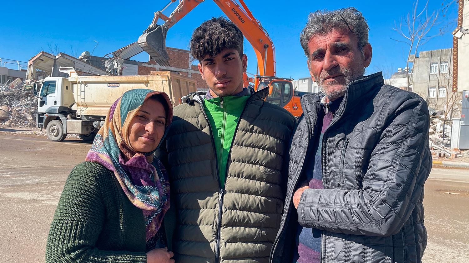 17-årige Taha Erdem med mamma Zeliha Erdem, och pappa Ali Erdem framför byggnaden som kollapsade och höll Tahan fången efter jordbävningen i Adiyaman, Turkiet. 