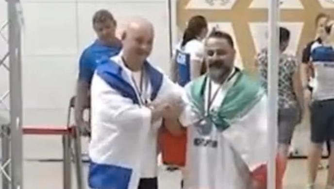 Israelen Maksim Svirsky och iraniern Mostafa Rajaei tar varandra i hand.
