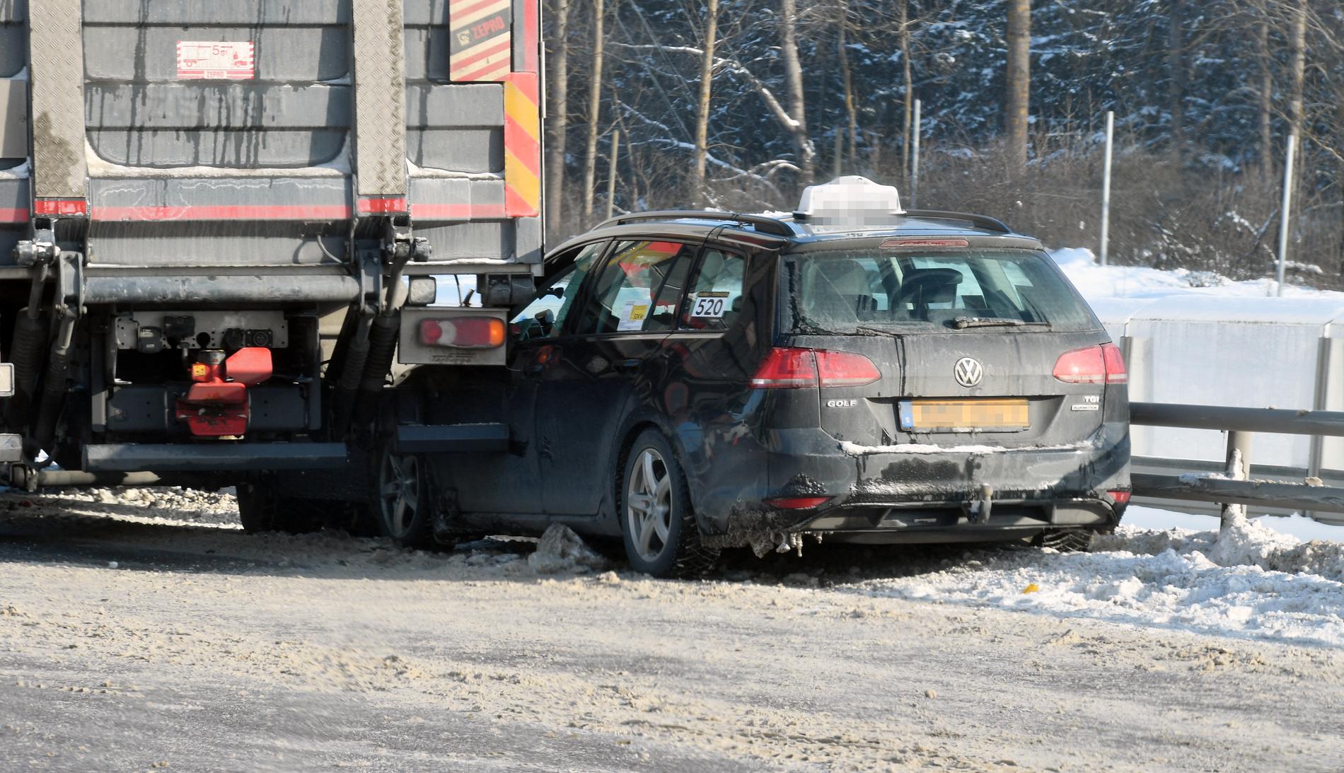 En taxi har kört in i en lastbil i halkan vid Kymlingelänken, Stockholm.