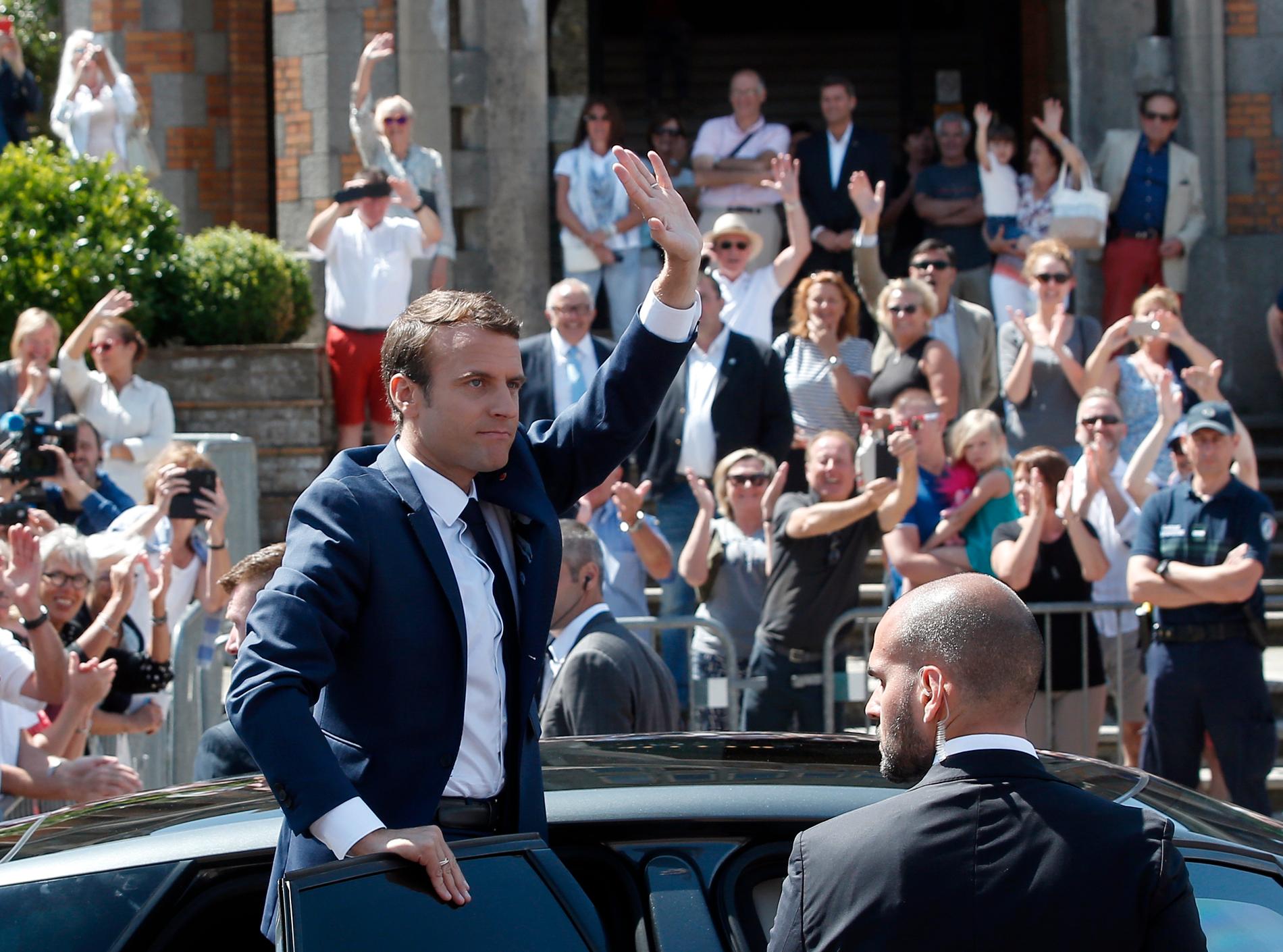 Frankrikes president Emmanuel Macron vinkar när han lämnar vallokalen i Le Touquet i norra Frankrike.