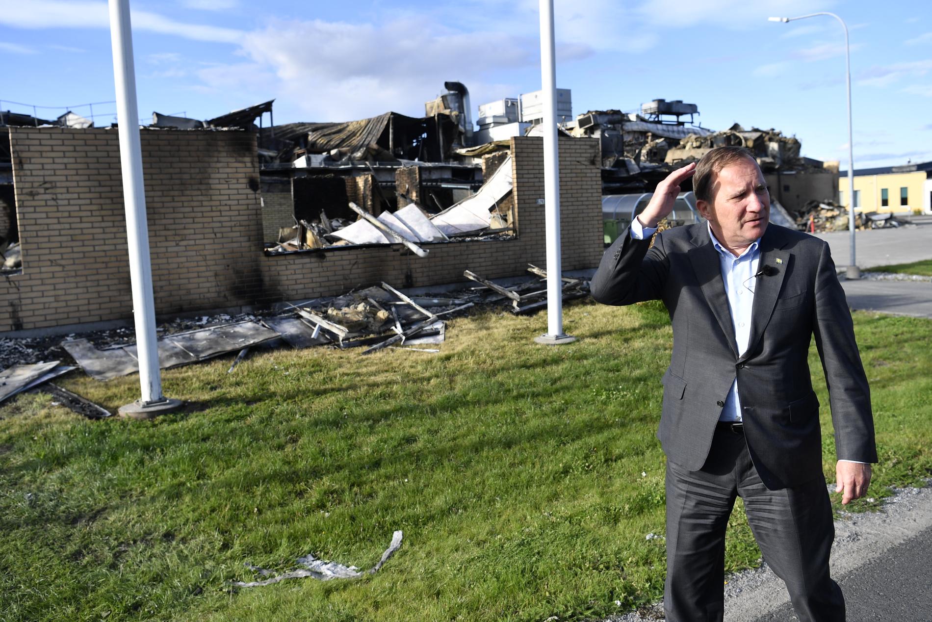Statsminister Stefan Löfven framför resterna av den nedbrunna brödfabriken Polarbröd i Älvsbyn.