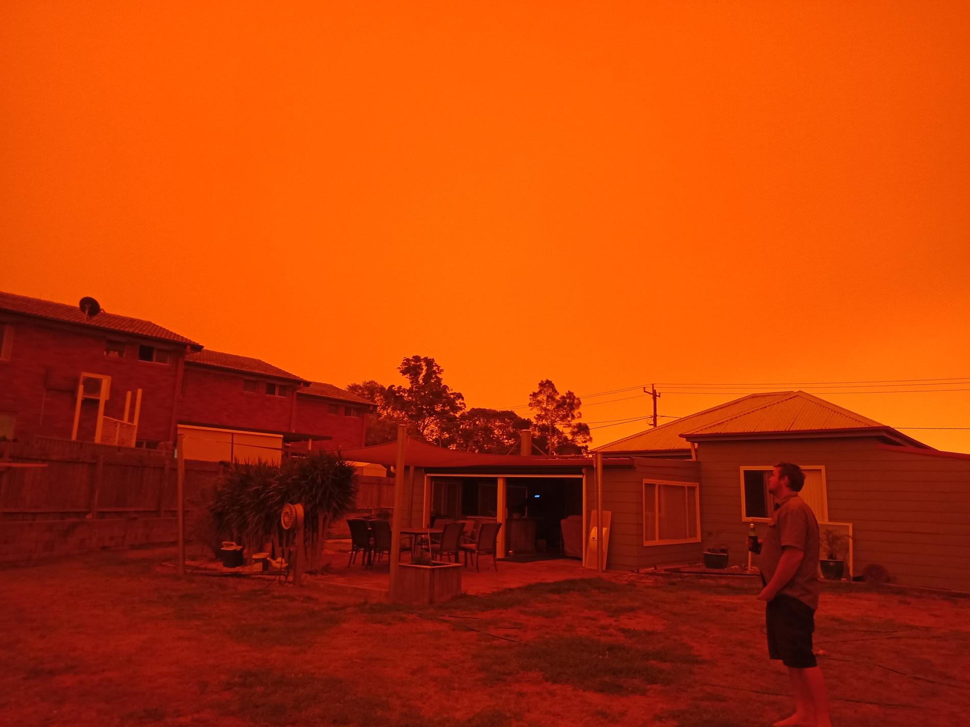 Bilderna från det rödorangea skenet i kuststaden har fått australisk media att kalla skogsbränderna apokalyptiska. 