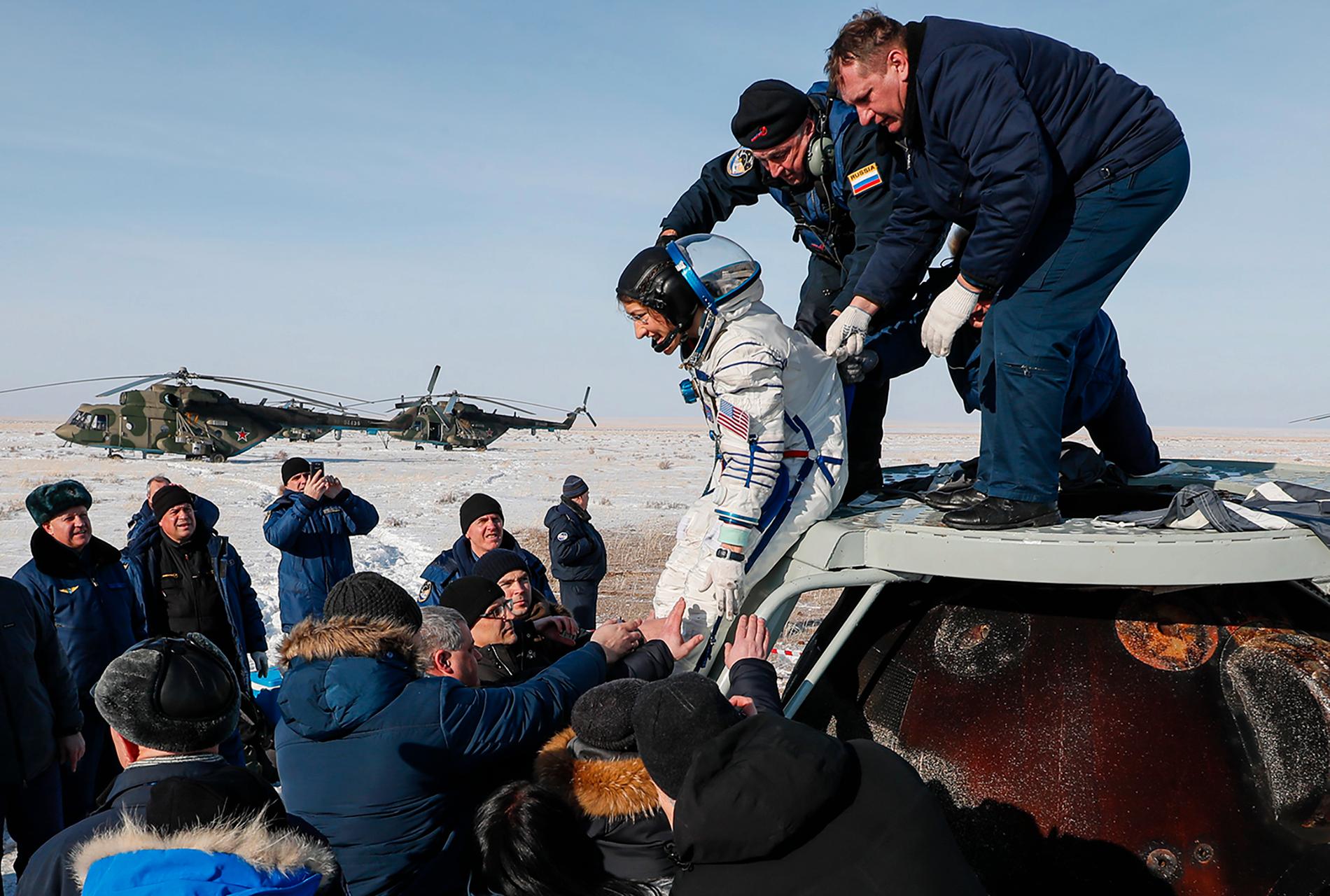 Den amerikanska astronauten Christina Koch får hjälp bort från kapseln strax efter landning i Kazakstan.