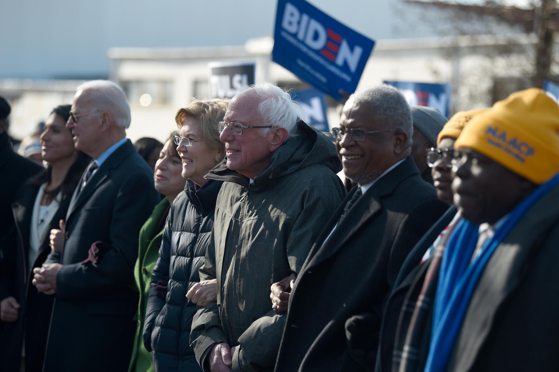 De demokratiska presidentaspiranterna Tulsi Gabbard, Joe Biden, Amy Klobuchar, Elizabeth Warren och Bernie Sanders går armkrok i en manifestation för att hedra fredspristagaren och medborgarrättsaktivisten Martin Luther King i South Carolina.