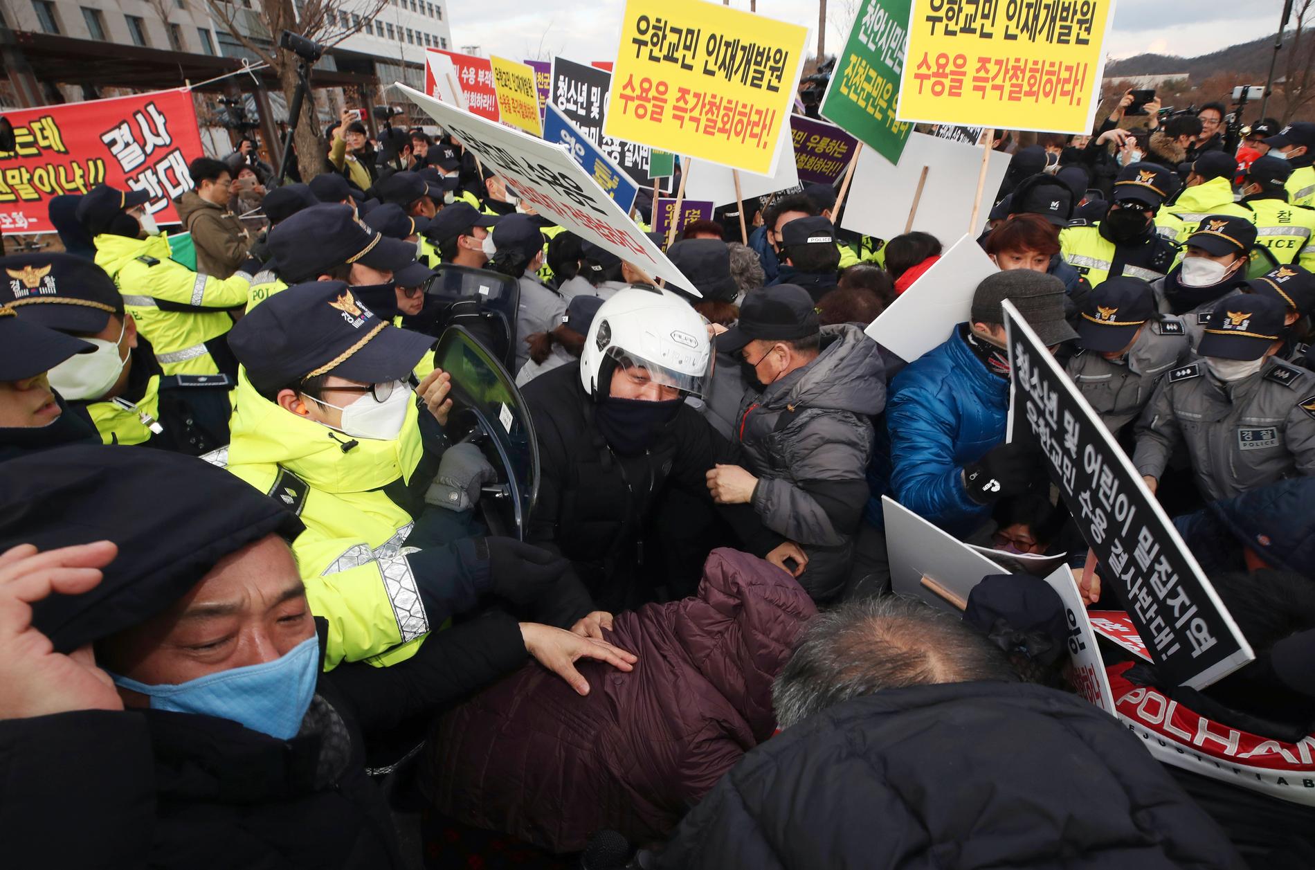 Invånare i staden Jincheon hamnade i tumult med polisen under en protest mot regeringens planer att sätta evakuerade i karantän i deras hemstad.