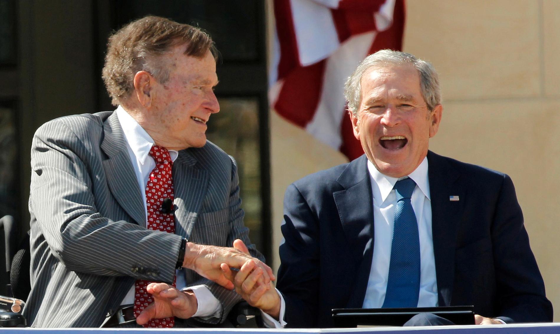 Father and son, both former U.S. Presidents, George H.W. Bush (L) and George W. Bush, shake hands at the dedication for the George W. Bush Presidential Center on the campus of Southern Methodist University in Dallas, Texas April 25, 2013.