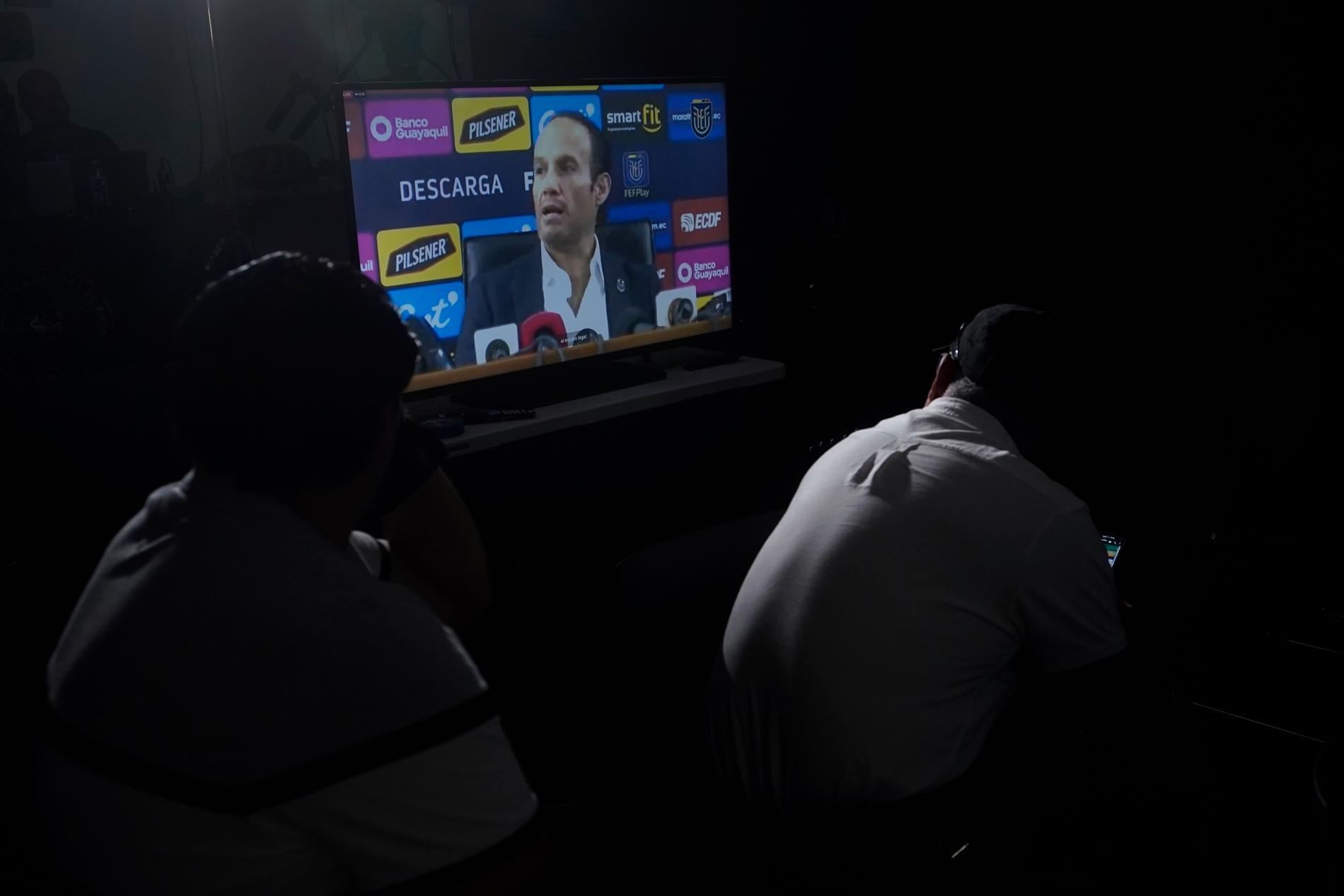 Supportrar tittar på en presskonferens med ordföranden för Ecuadors fotbollsförbund, Francisco Egas, i juni angående uppgifterna om Byron Castillo.