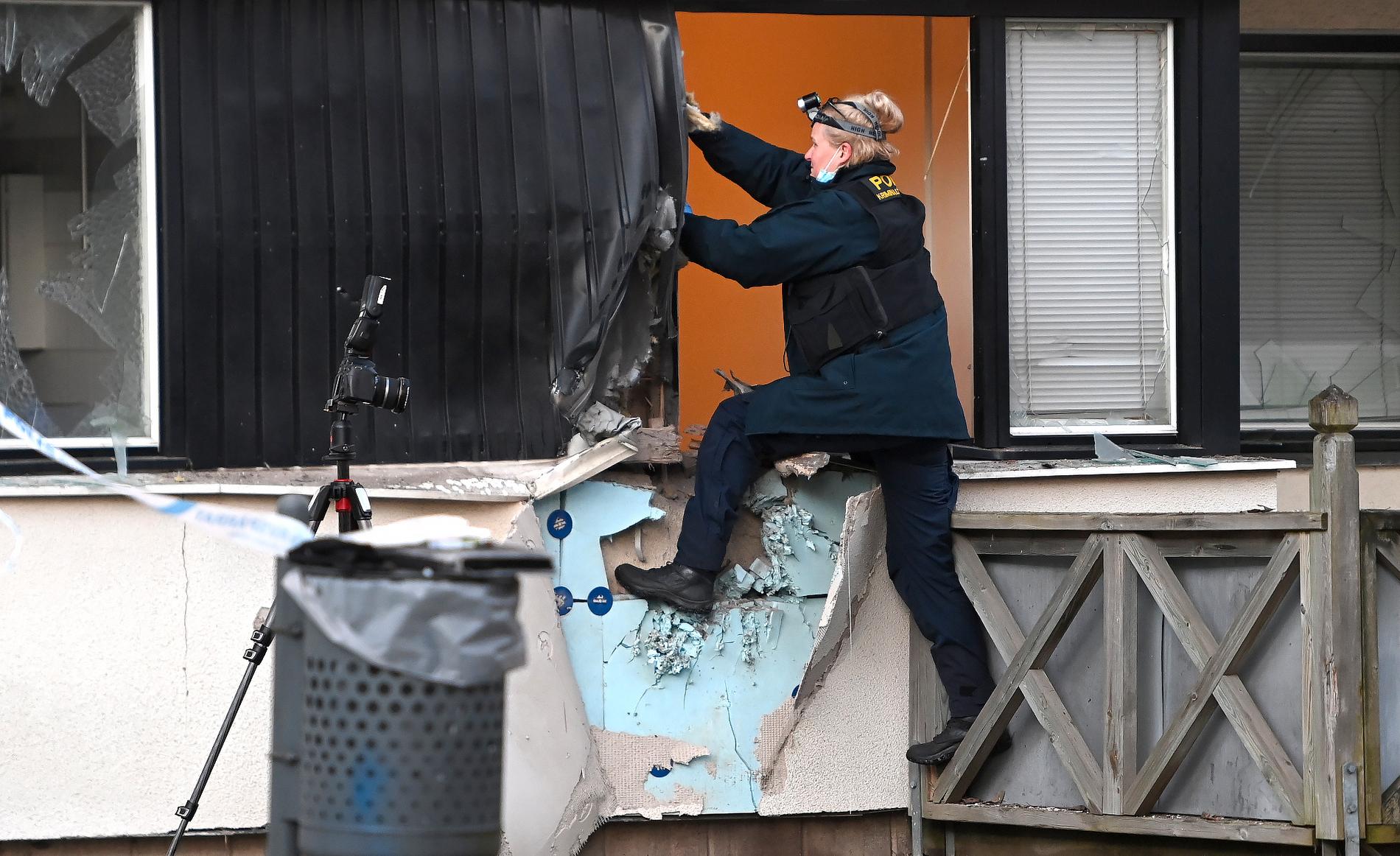 En polis undersöker en lägenhet efter explosion i Skpgås utanför Stockholm.