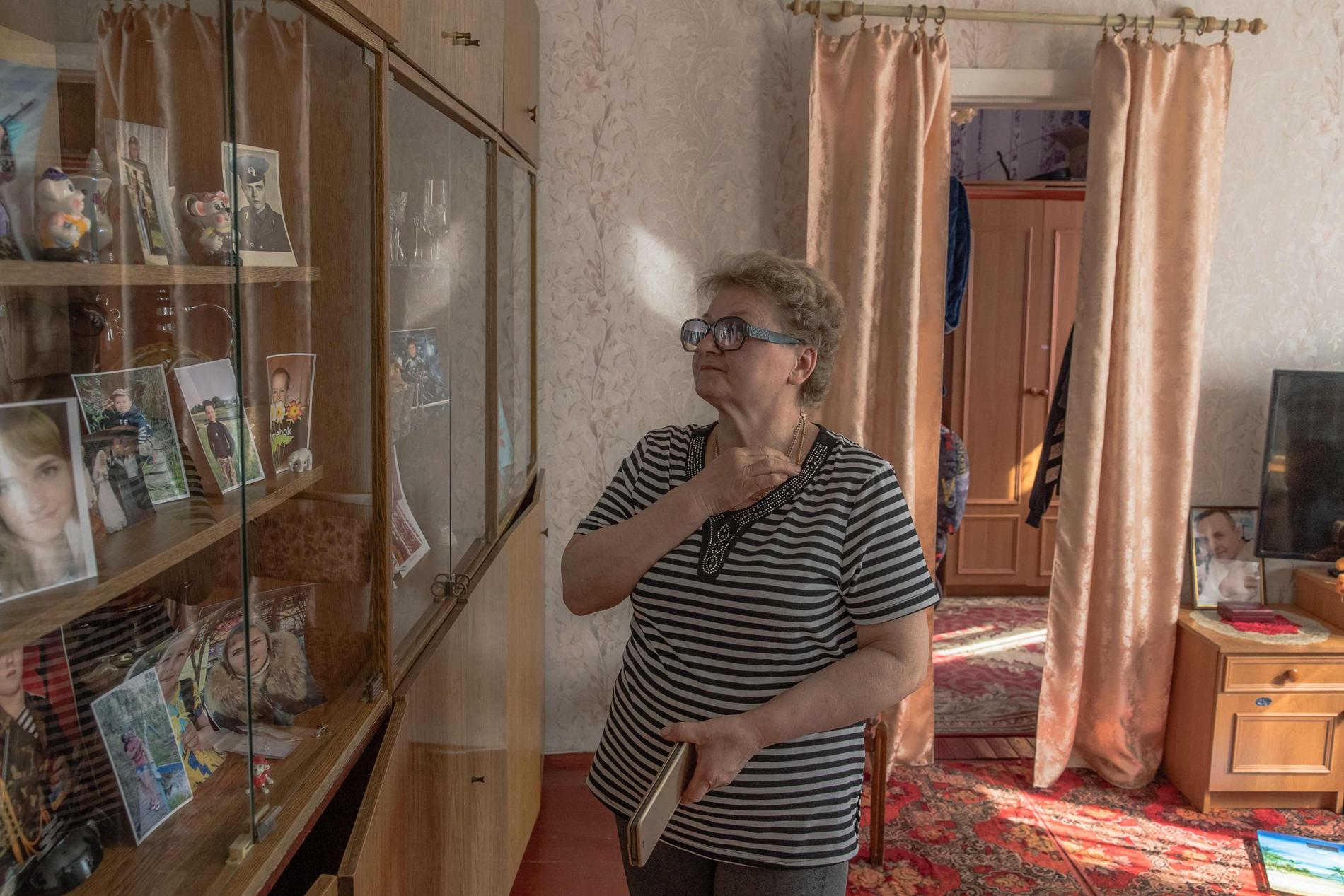 Valentyna Kozyr, 56, tittar på bilder av släktingar som dödades i attacken i oktober.