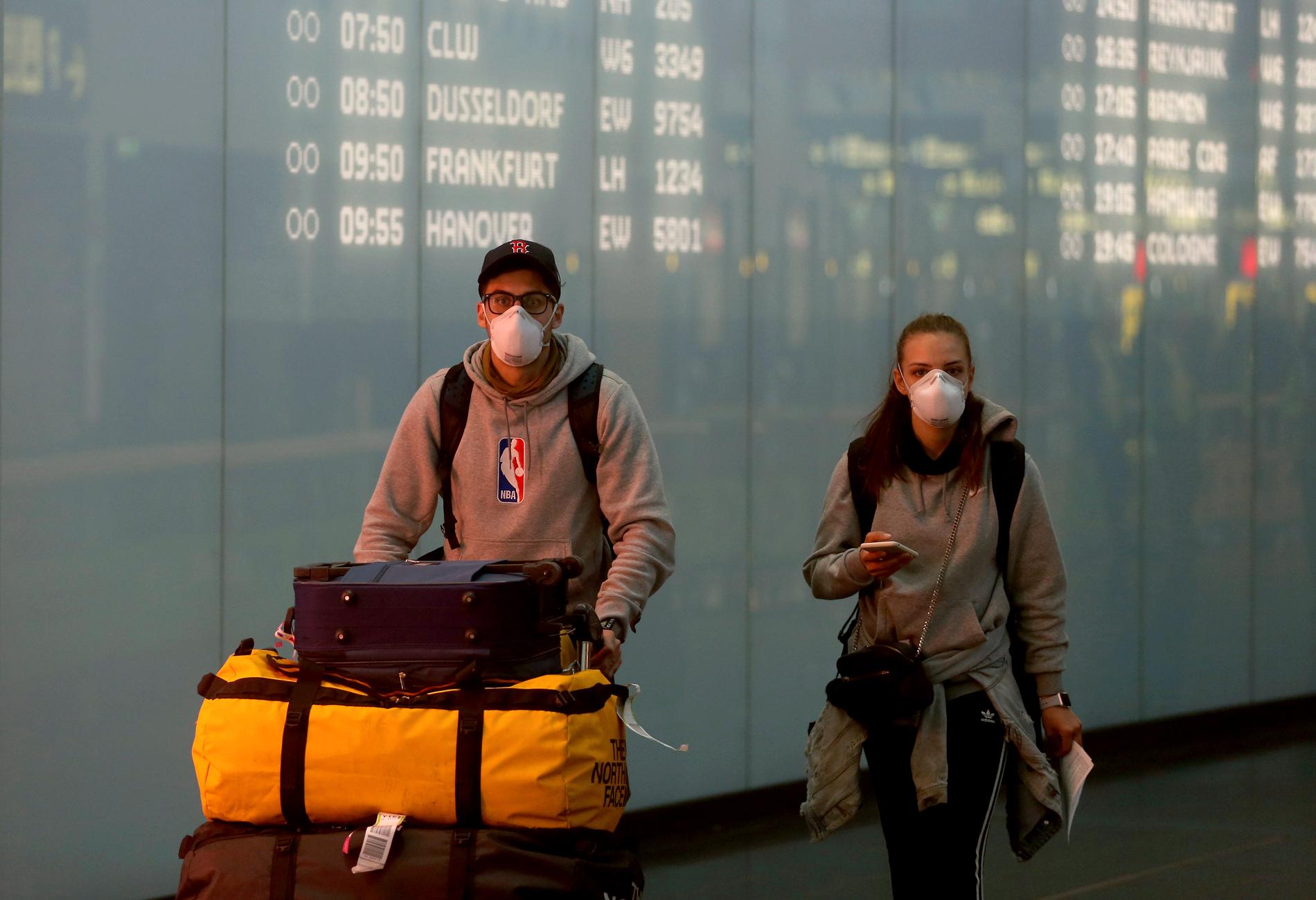 Resenärer med munskydd på flygplatsen Schwechat i Wien.