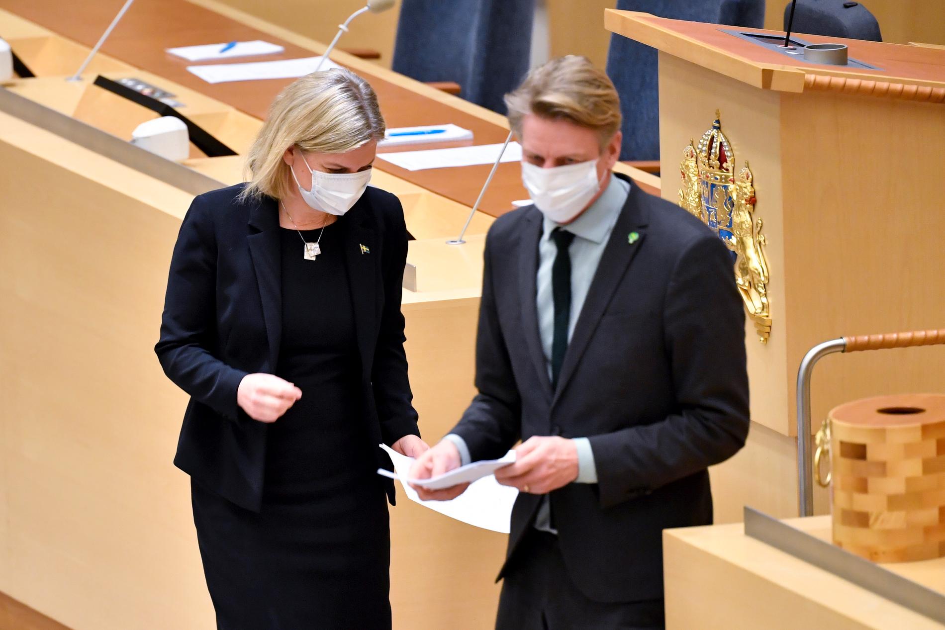 Socialdemokraternas partiledare Magdalena Andersson (S) och Miljöpartiets språkrör Per Bolund (MP) under dagens partiledardebatt i riksdagen. Båda är nu smittade med covid-19.