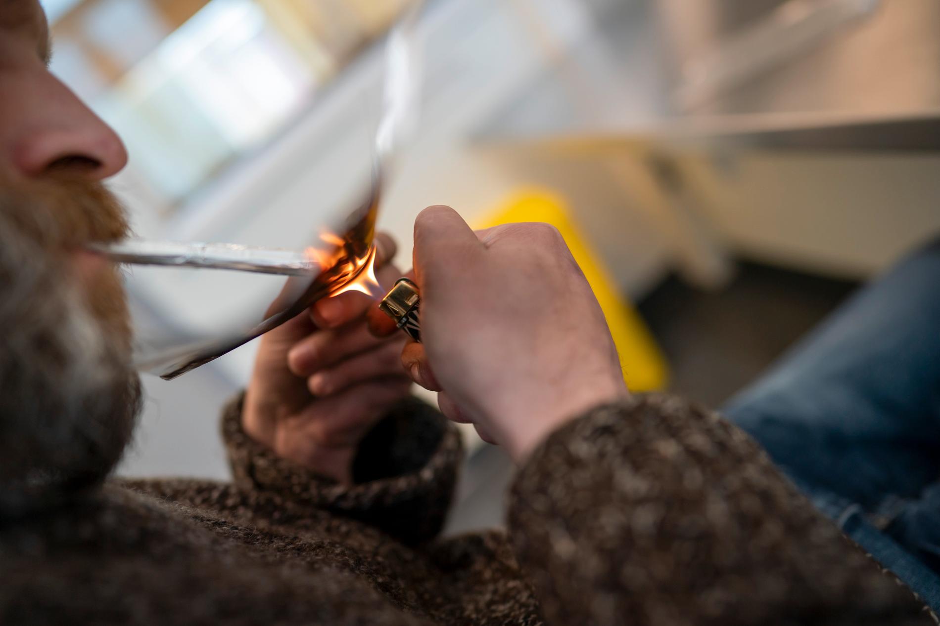 En man beroende av heroin röker drogen i ett speciellt rökrum som öppnade i Oslo under sommaren 2020. Några liknande finns inte i Sverige.