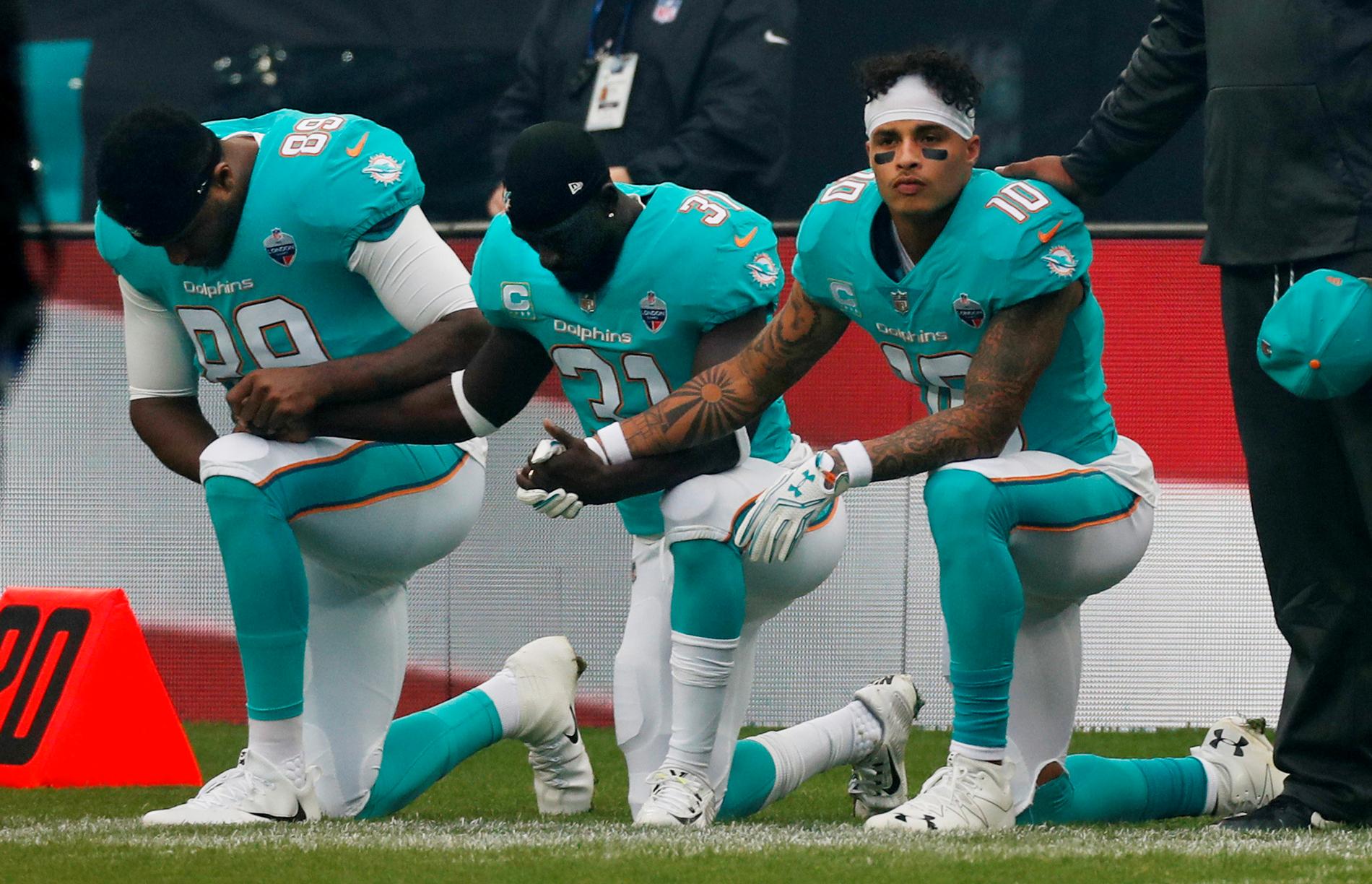 Miami Dolphins spelare går ned på knä inför söndagens match.