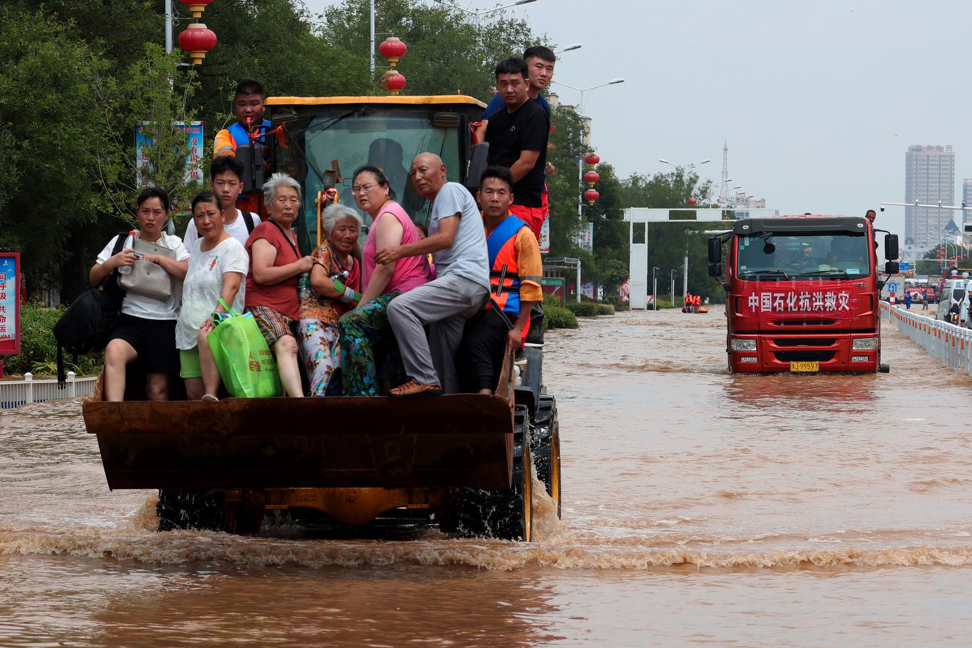 Människor räddas undan översvämningarna i Henan i Kina.