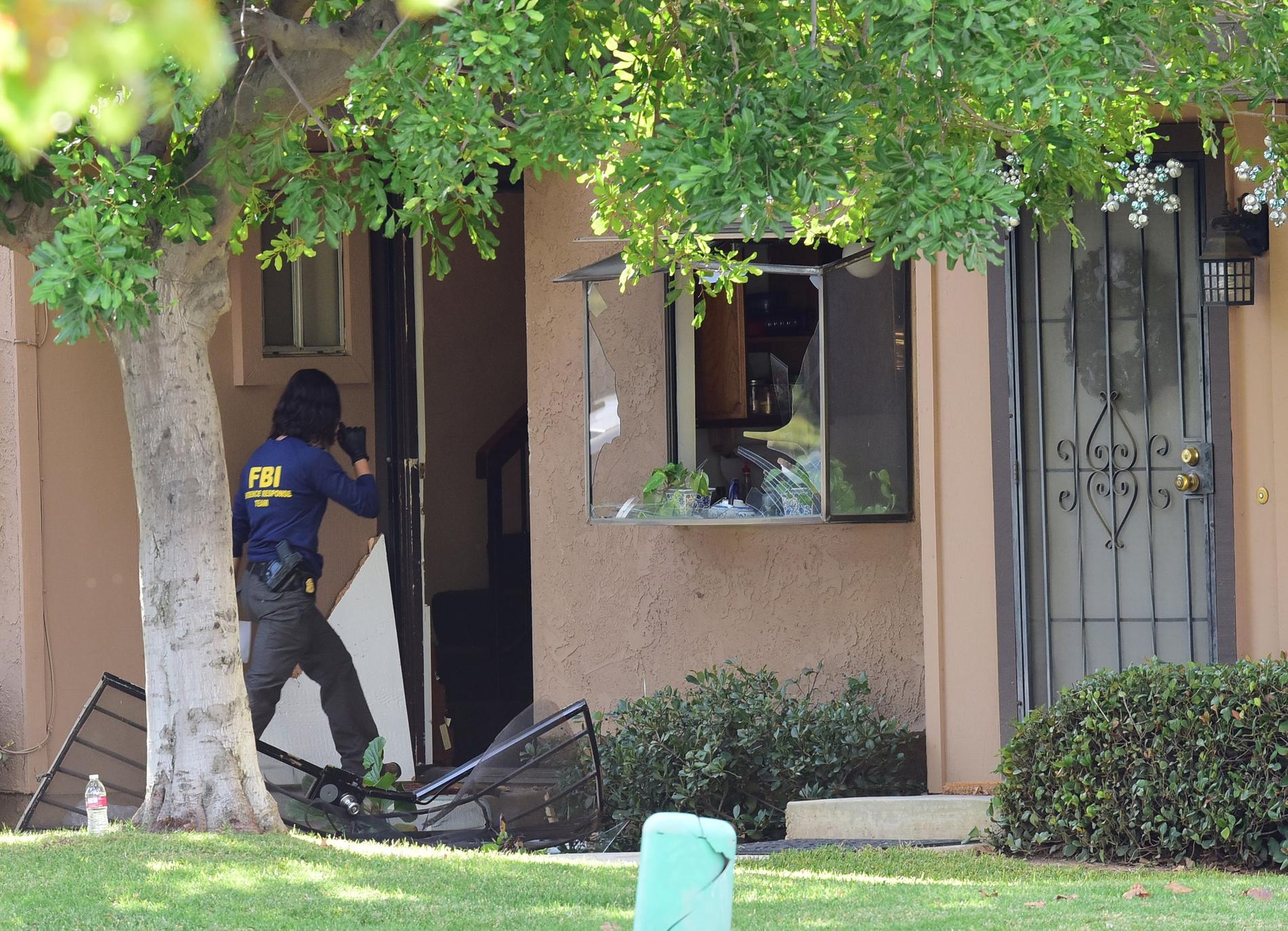 FBI tekniker undersöker ett hus som sätts i samband med de misstänkta.