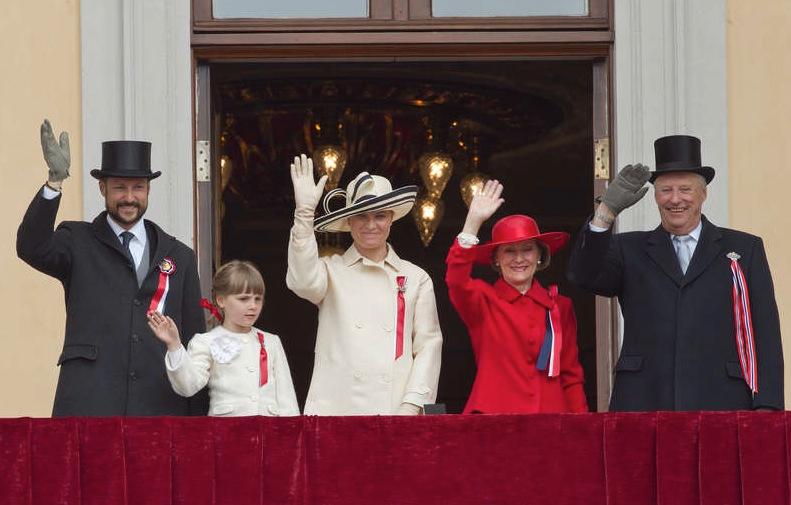 Kronprins Haakon, prinsessan Ingrid Alexandra, kronprinsessan Mette Marit, drottning Sonja och kung Harald står och vinkar.