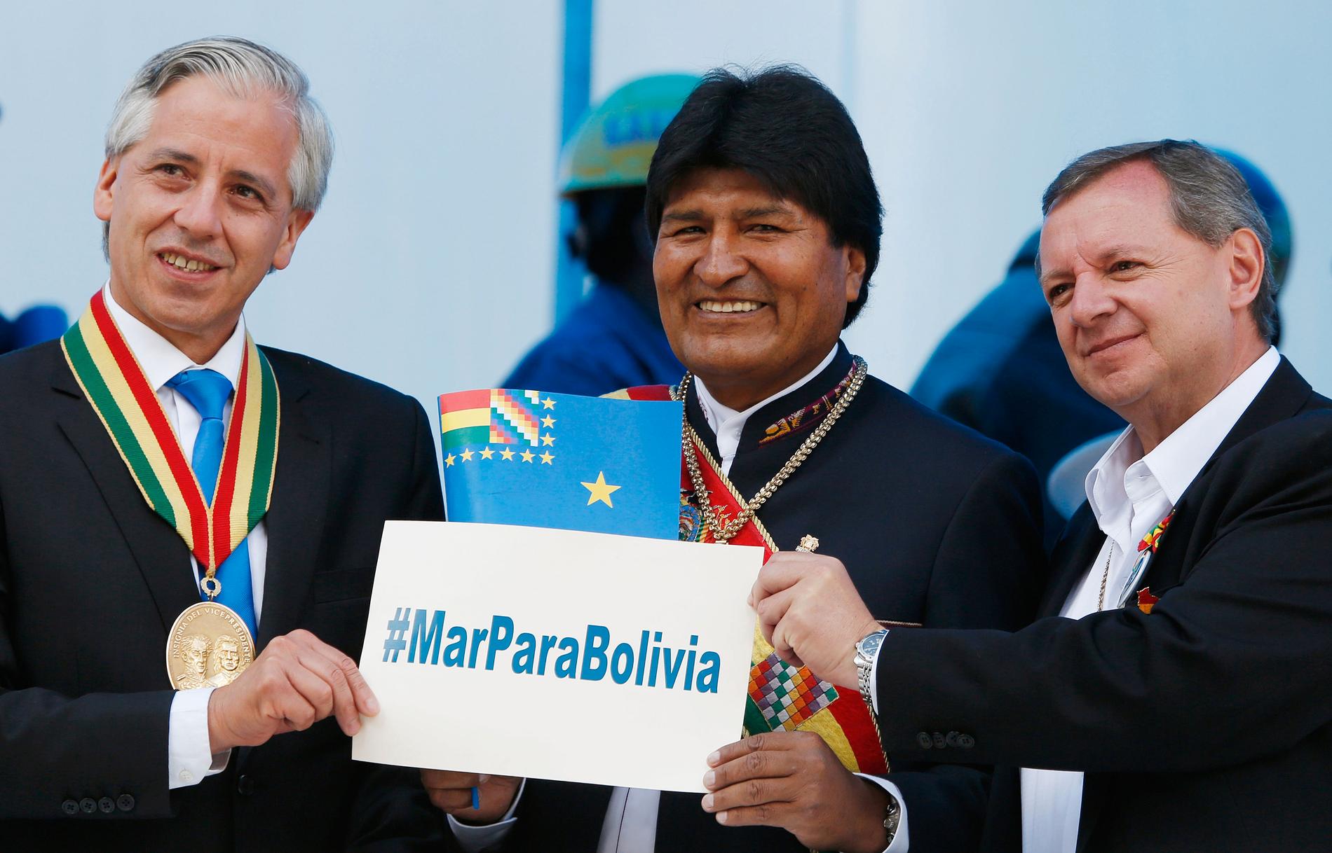 Bolivias president Evo Morales, i mitten, håller upp en skylt med budskapet "Hav åt Bolivia", tillsammans med landets vicepresident Álvaro García Linera, till vänster, under en manifestation i La Paz 2015.