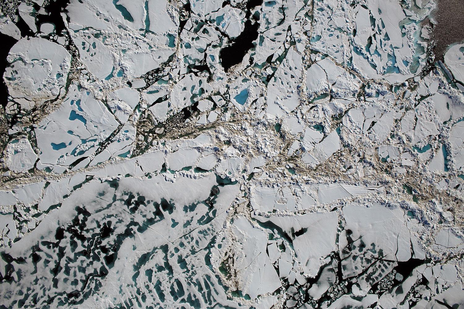 Flygbild från Tjkterhavet i Arktis visar havsis, dammar med smältvatten och öppet hav.